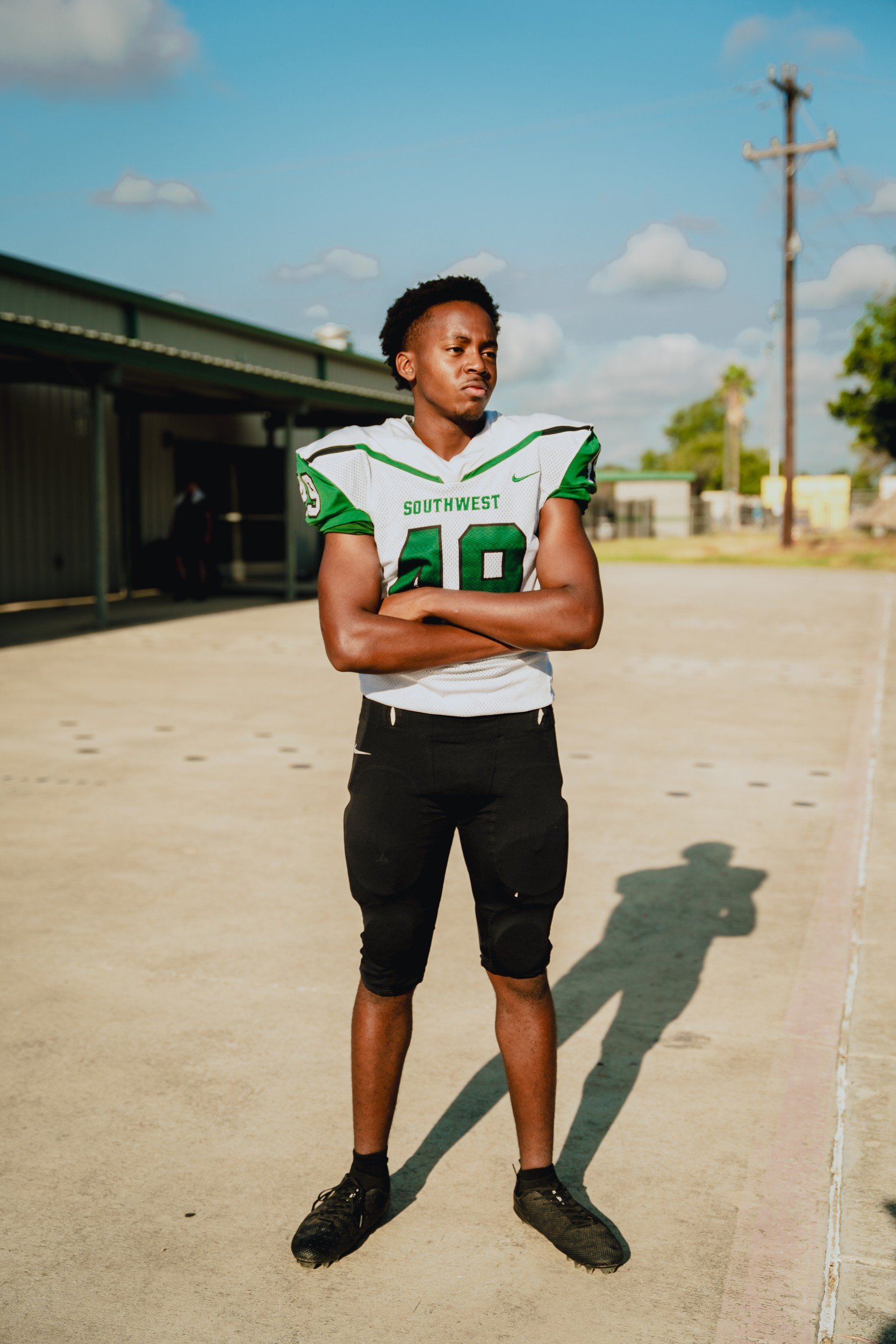 Full-length athlete portrait in uniform outdoors.