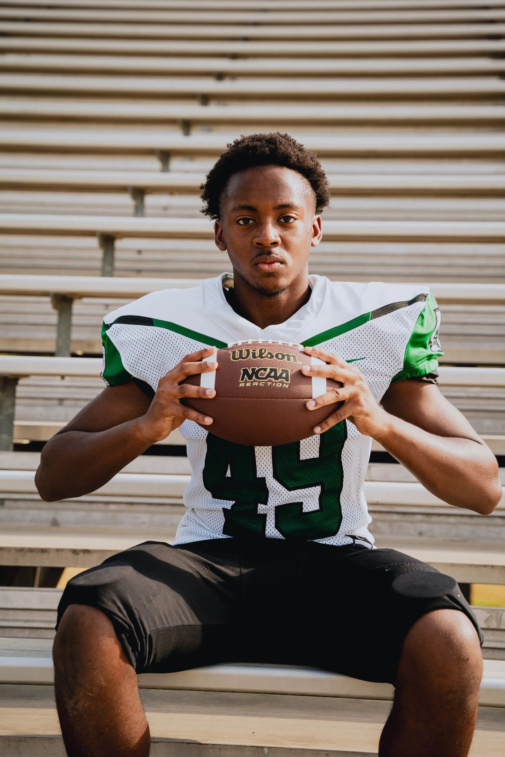 Jaelin holding a football for an athlete portrait.