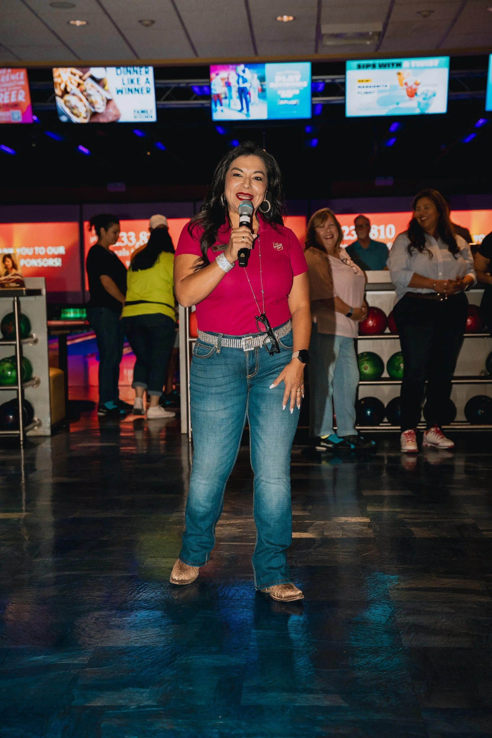 Speaker holding a microphone at the bowling event.