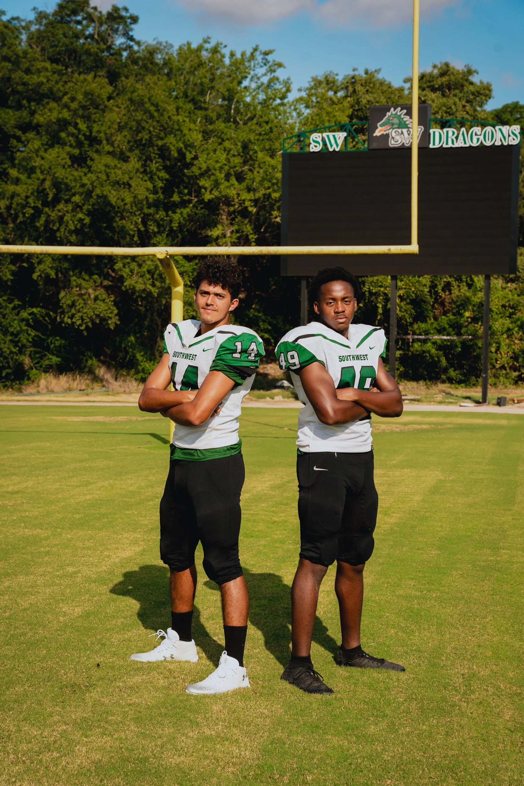 Two athletes posing together in uniform.