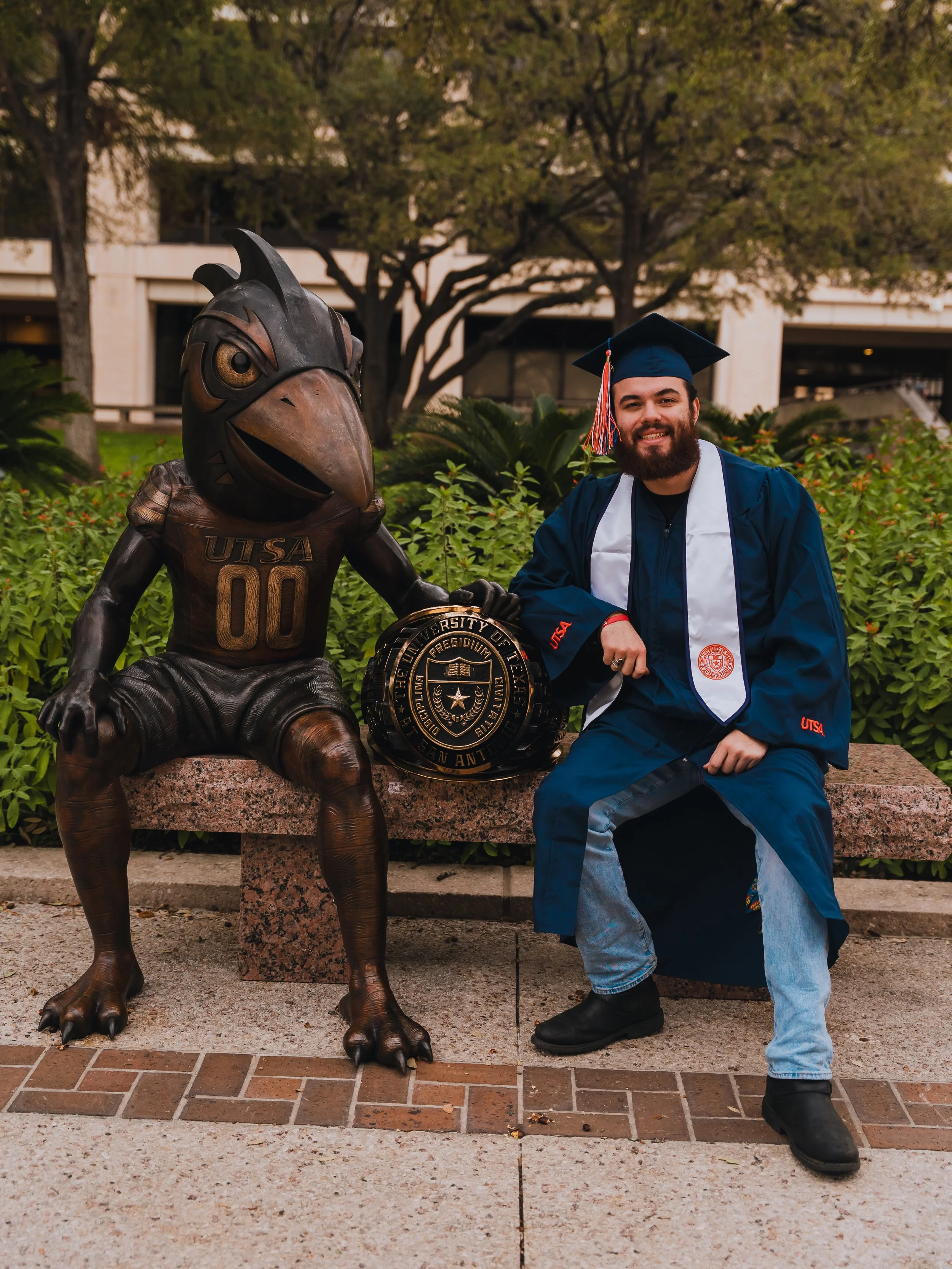 Antonio Mayhar of Antwan Productions smiling in graduation attire at UTSA