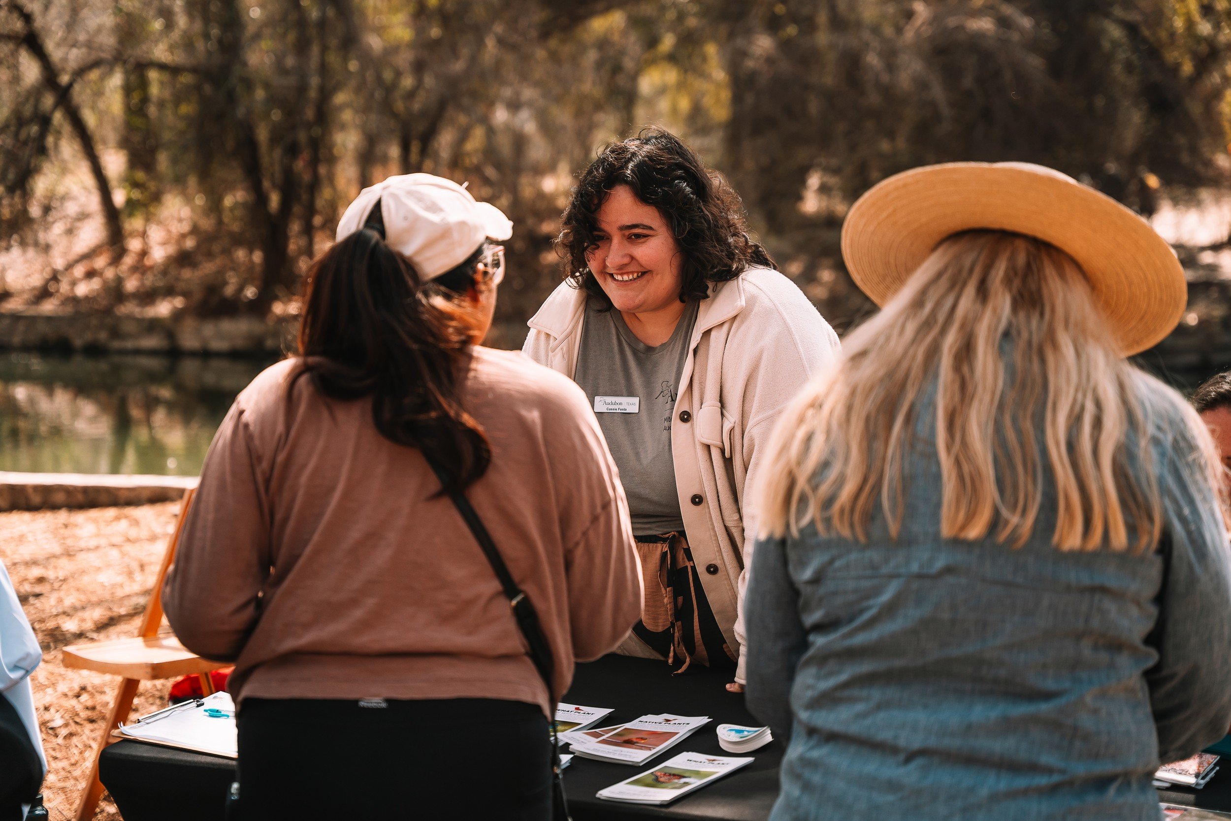 Guests talking at an information booth during the Basura Bash community event.