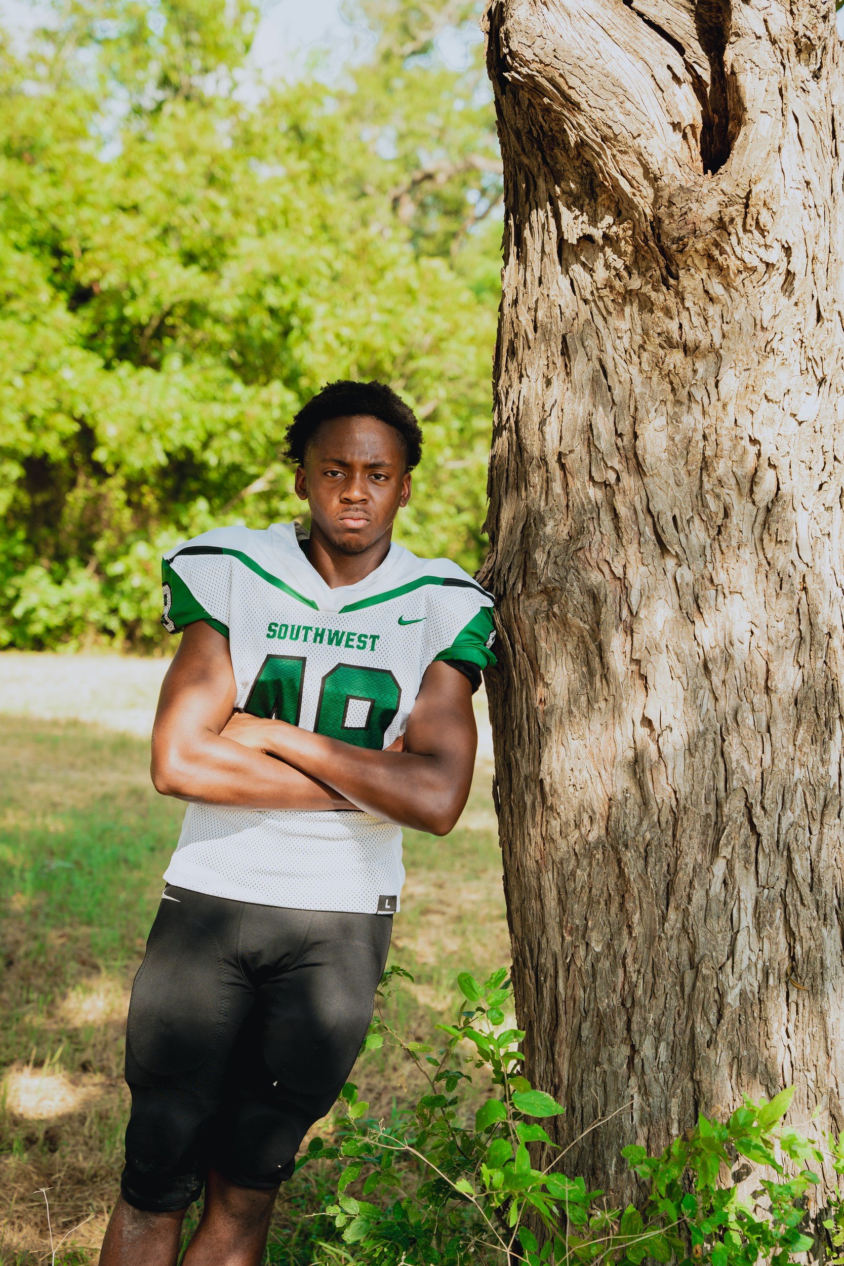 Athlete portrait beside a tree.