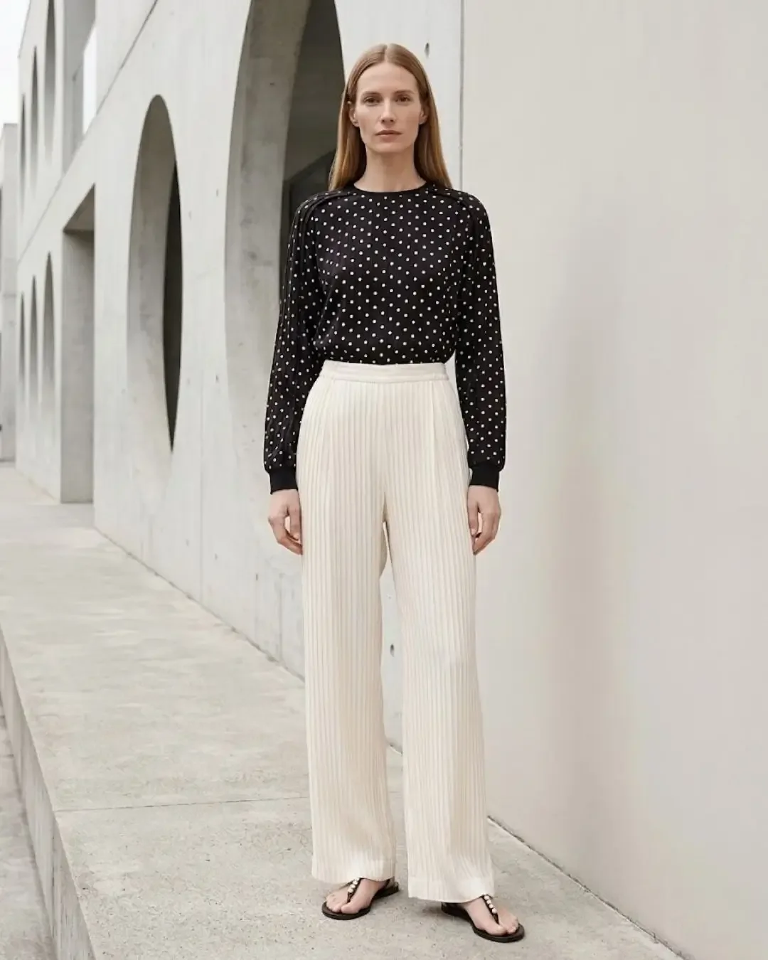 Black polka dot blouse with cream pleated wide-leg pants — polka dot outfit ideas by Wonder Wardrobe for spring 2026.