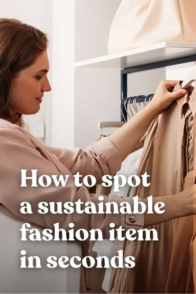 A woman examining a garment in a store to check fabric quality and materials for sustainable fashion decisions.