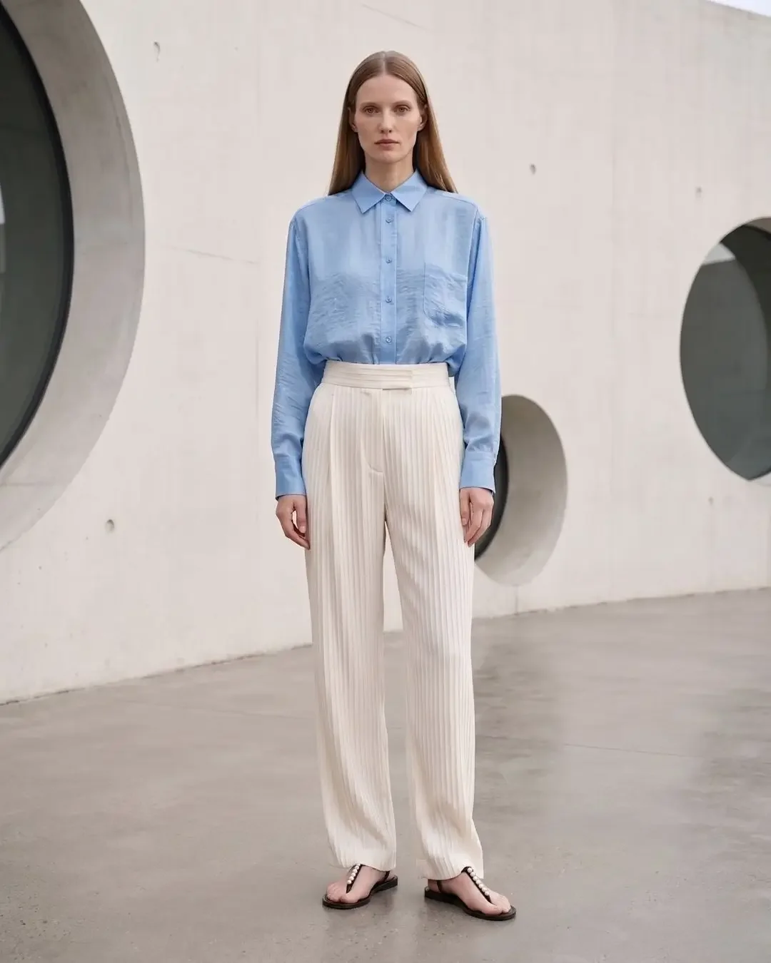 Light blue silk shirt with cream pleated wide-leg trousers — pleated trousers, Dalí-inspired spring capsule wardrobe 2026.