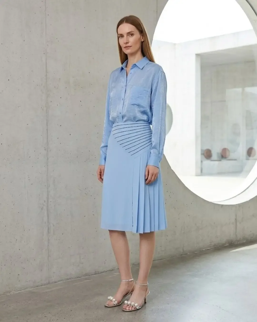 Light blue silk shirt with pleated blue midi skirt — cool tones and pleated skirt outfits from the spring capsule wardrobe 2026.