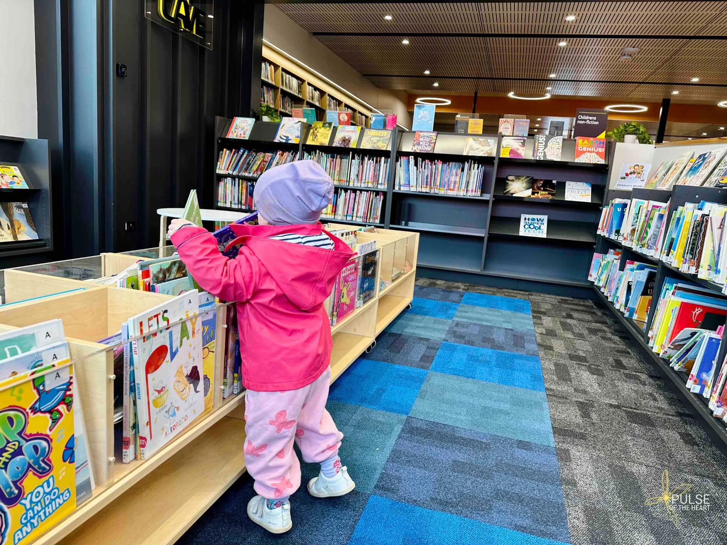 Toddler choosing picture books in children's area of Naracoorte Library.