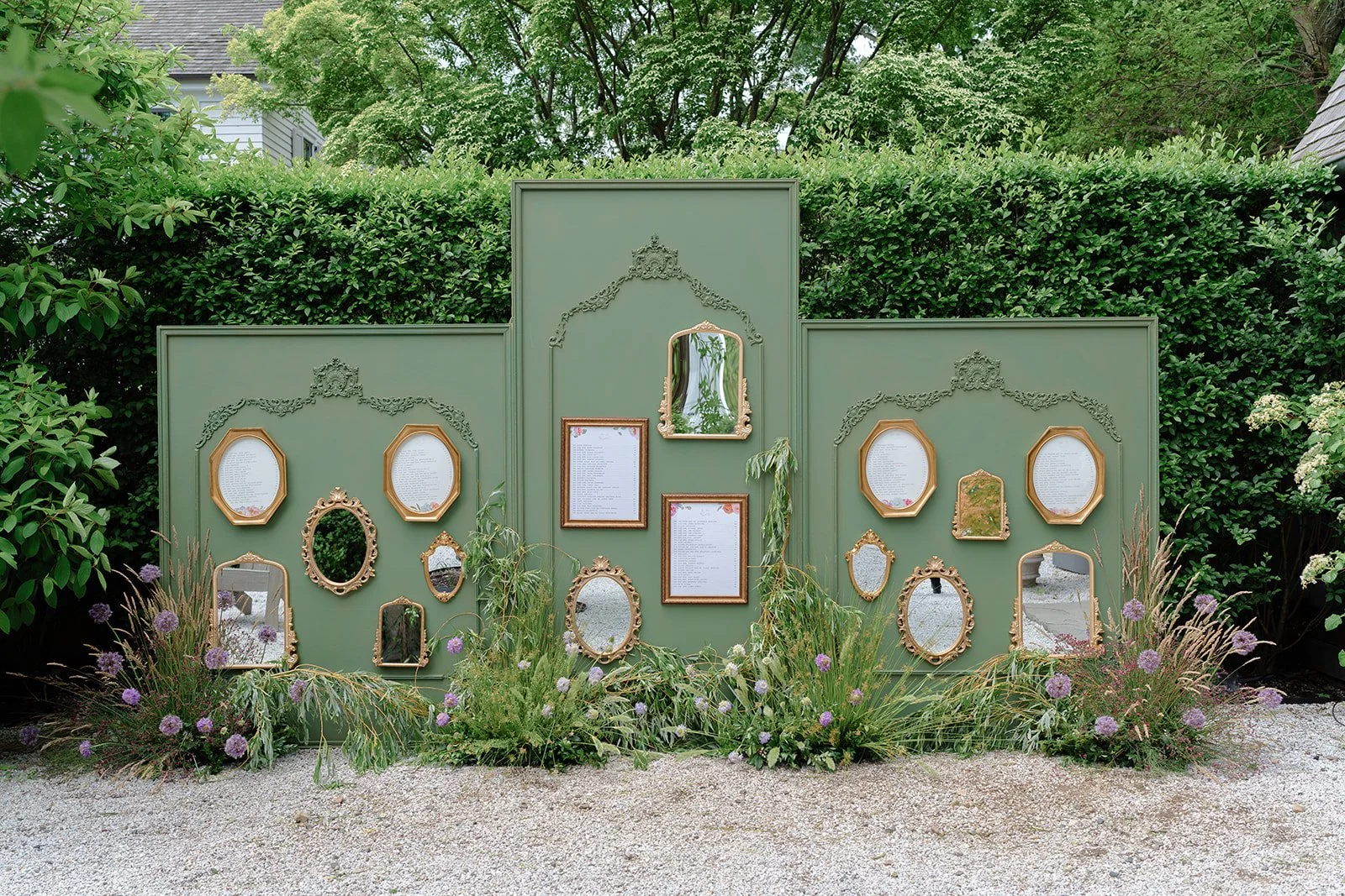 Wedding seating chart wall. A beautiful green wall with gold framed mirrors scattered  with gold framed seating charts interspersed. It's a beautiful statement piece!