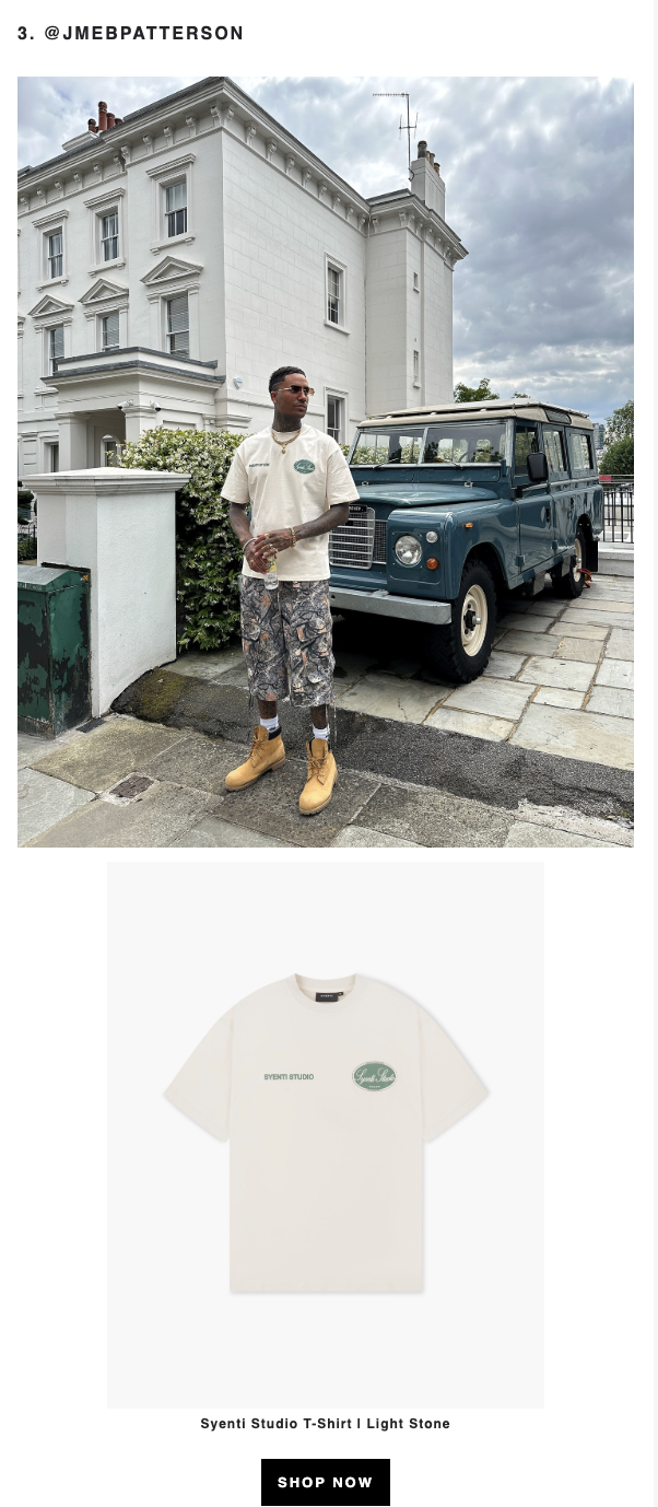 A man standing on a sidewalk in front of a white house and a vintage blue Land Rover. He is wearing sunglasses, a beige T-shirt, camouflage shorts, and tan boots.