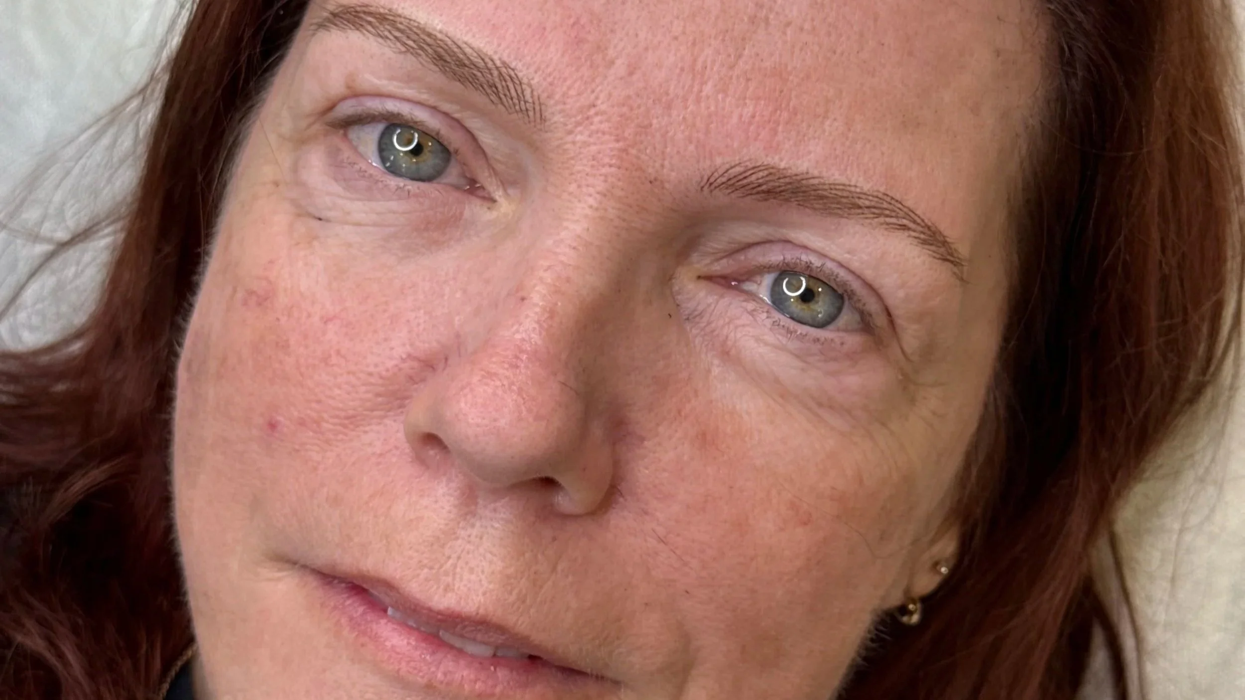 redheaded woman with blue eyes after realistic permanent nano brow