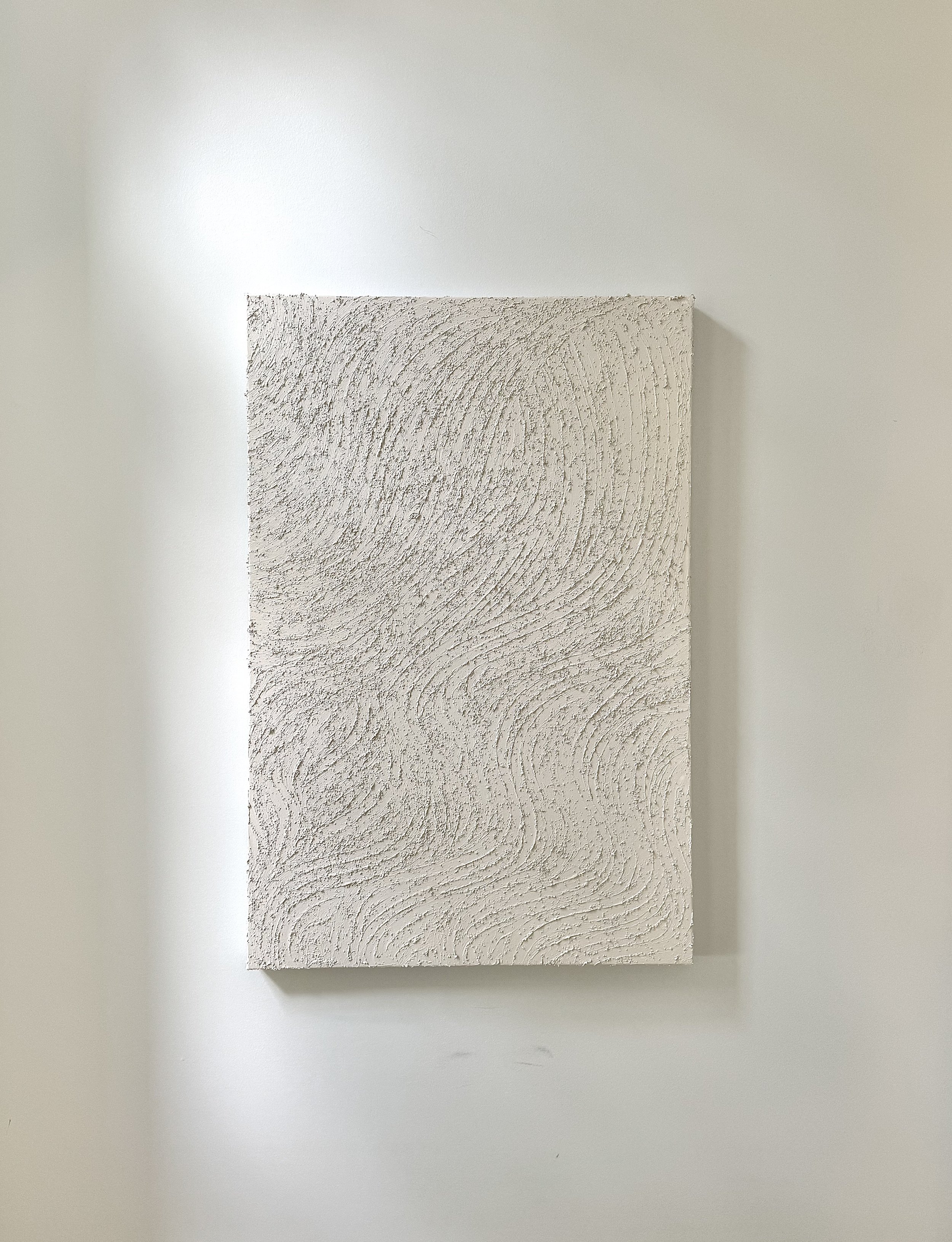 A light colored art piece, hung on the wall, unframed and on canvas.