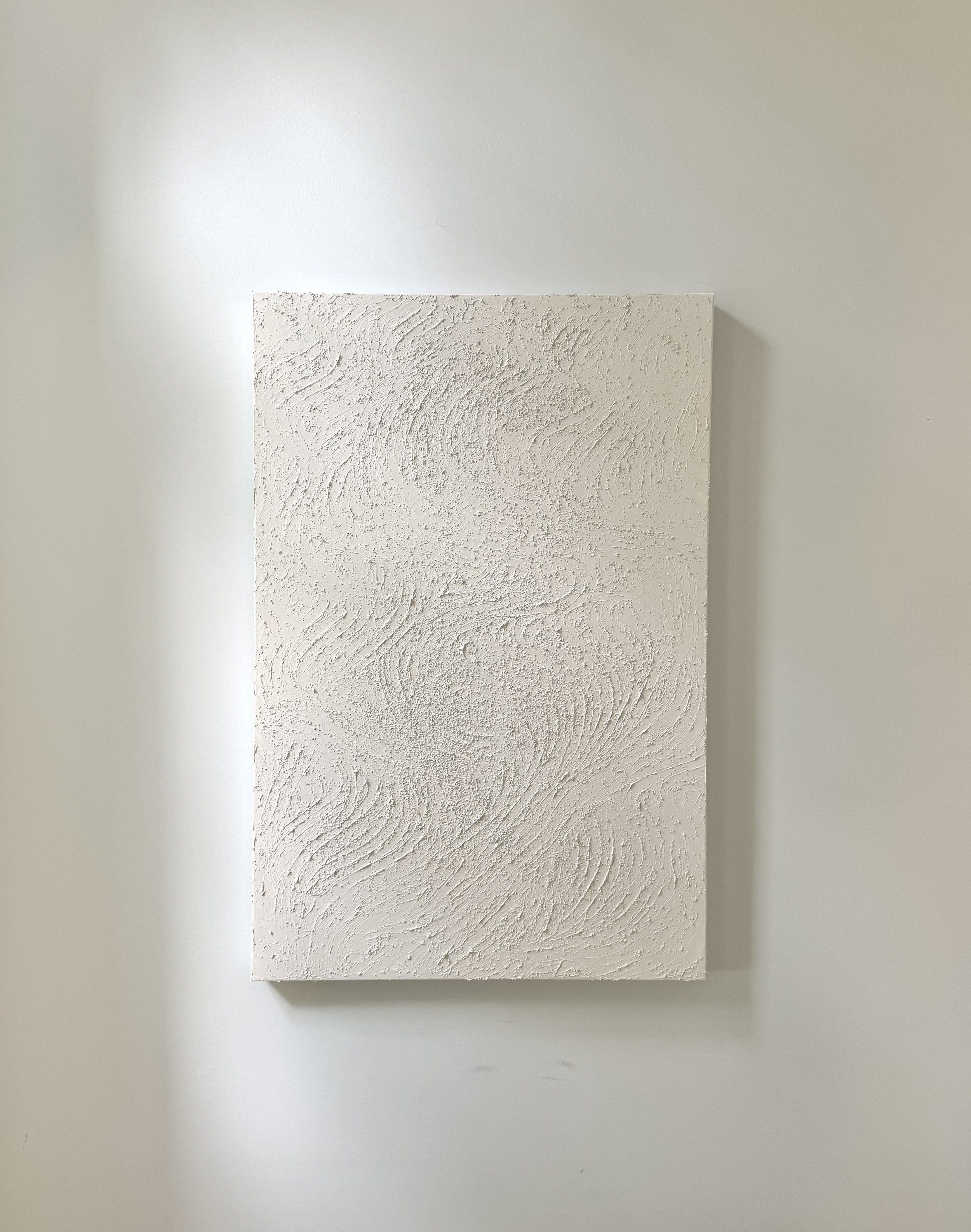 A light colored artwork, hung on the wall, unframed and on canvas.