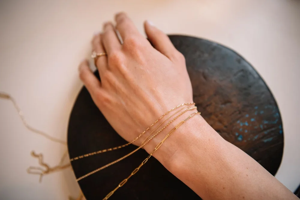 Hand wearing gold chain jewelry from Original Hardware