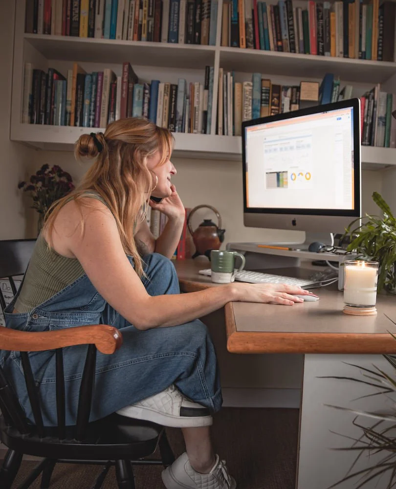 Carly Hopps, founder of Akoya Creative, working at her desk in Rockland, Maine