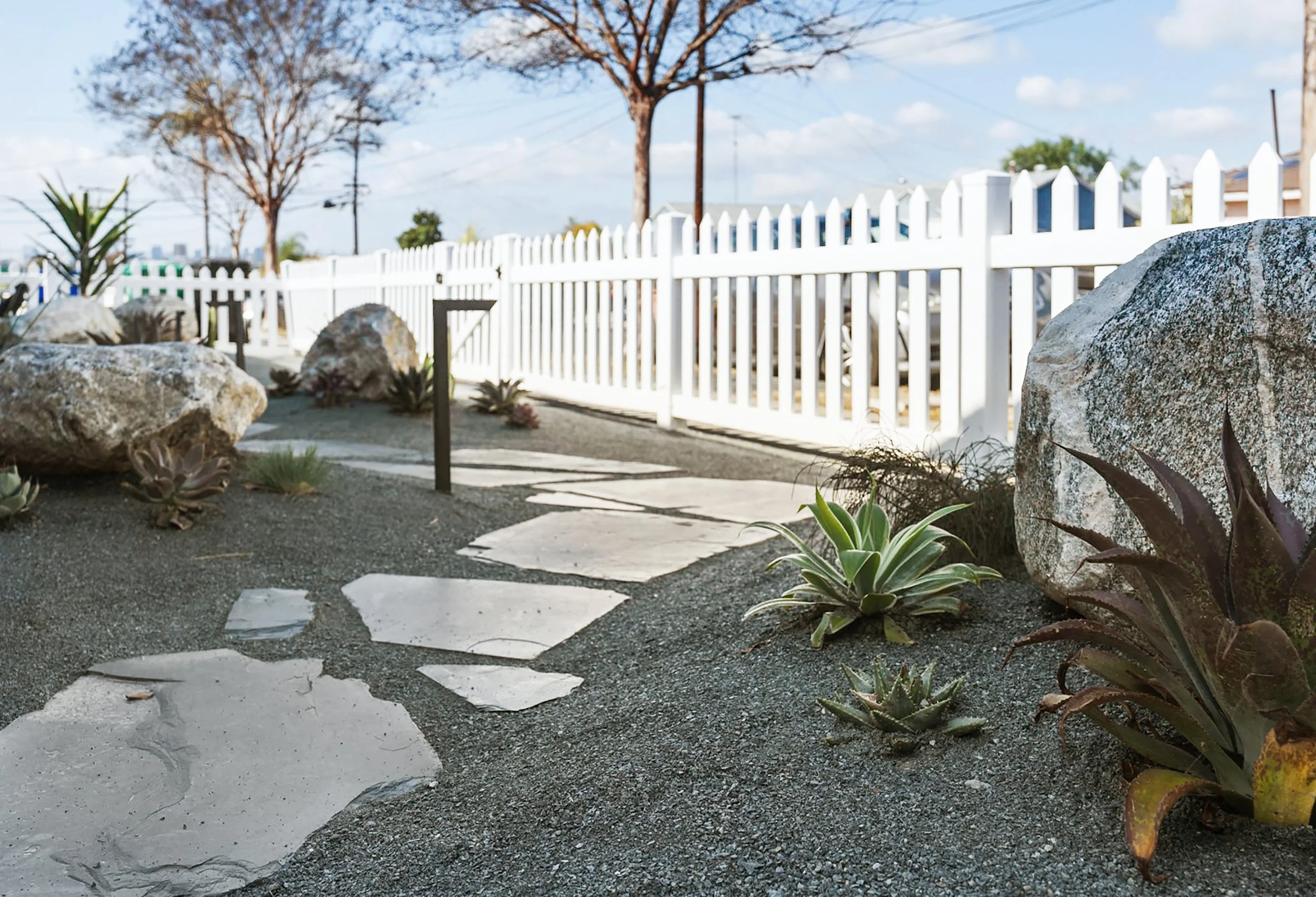 Front yard remodel including flagstone, boulders, plants, and lighting