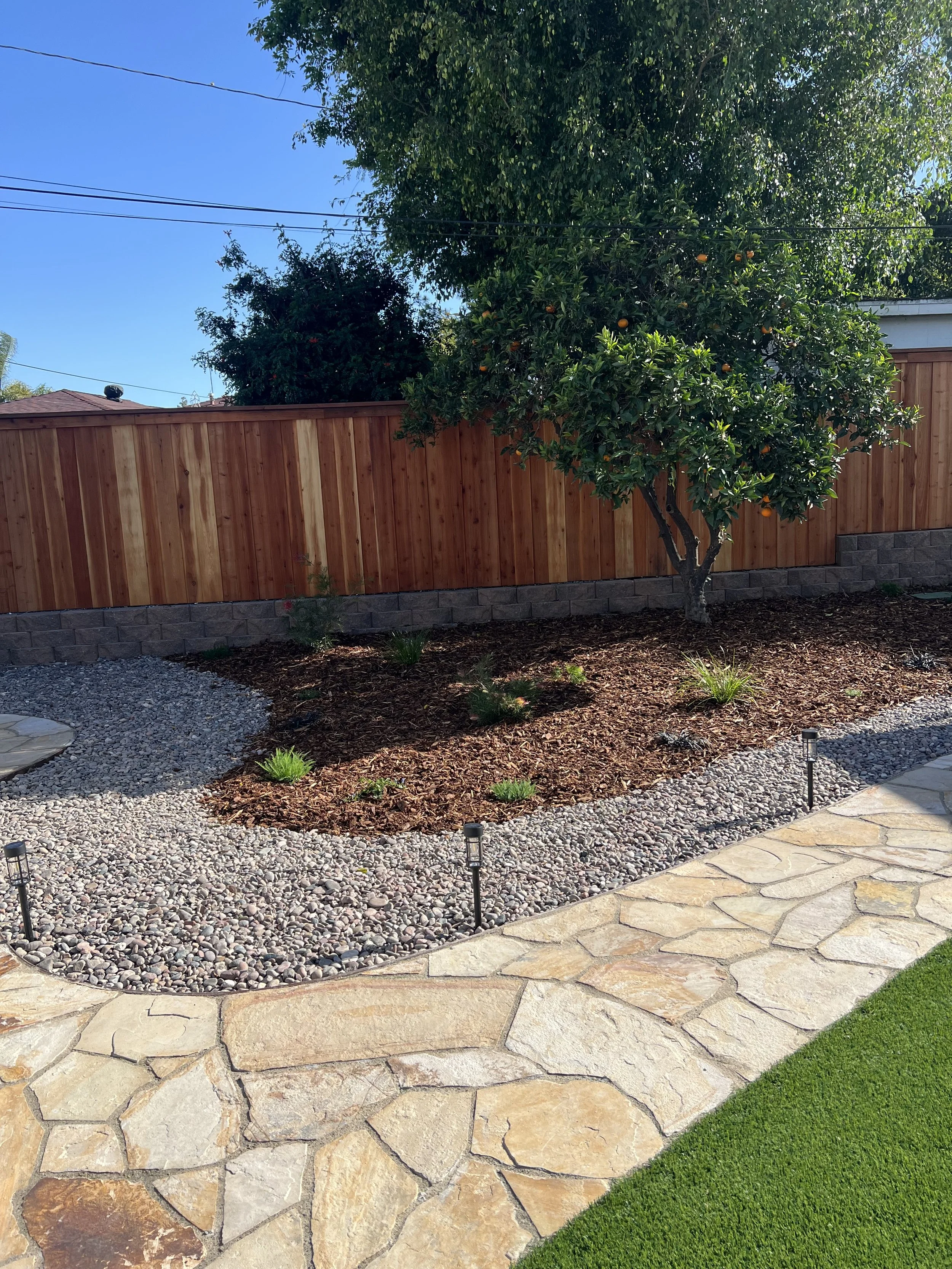 turf meets flagstone meets rocks meets mulch. Custom backyard remodel design in san diego.