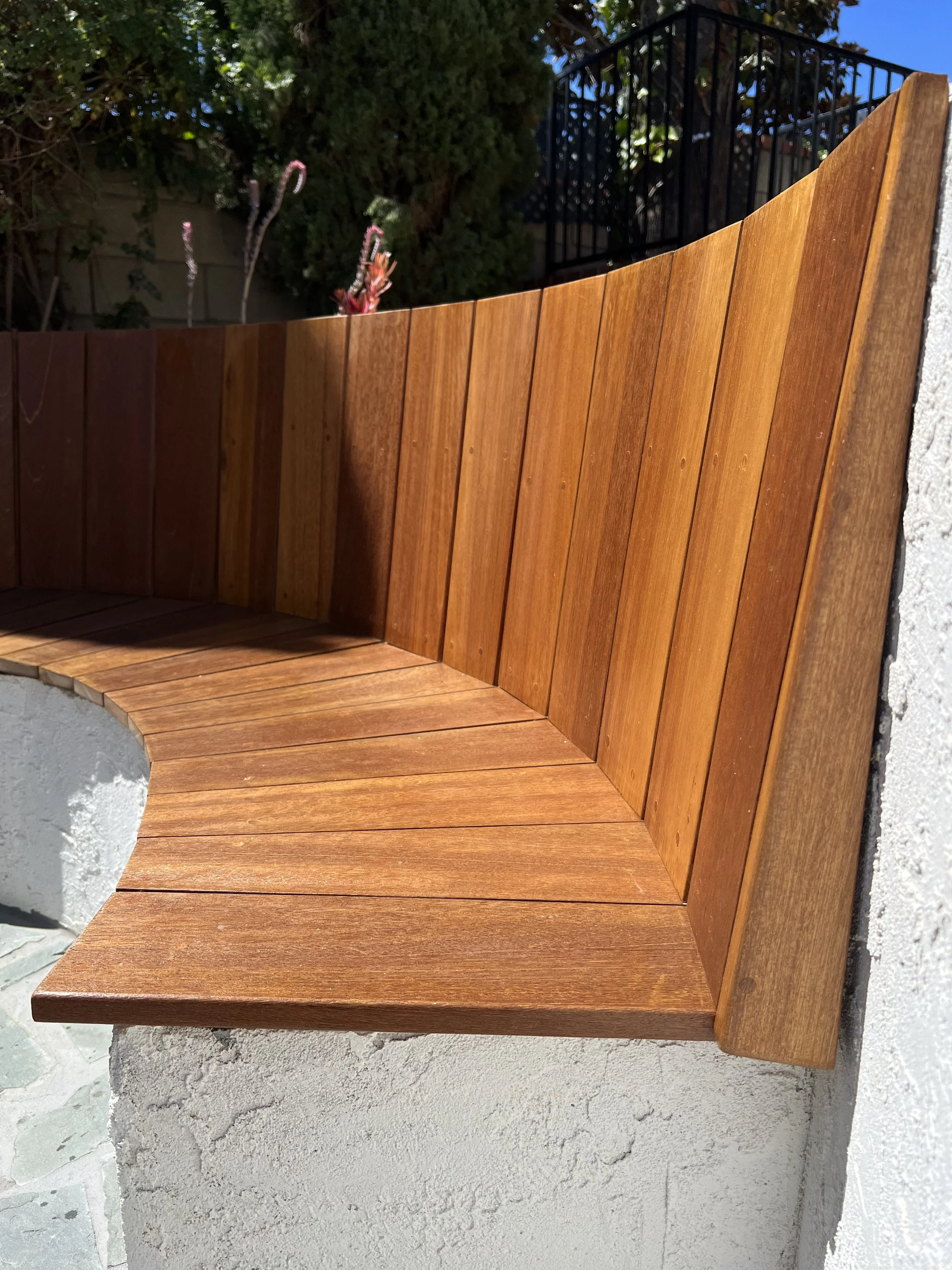 custom sunken seating made from premium wood. Originally a vintage fountain reclaimed into a seating area with a water feature in the middle