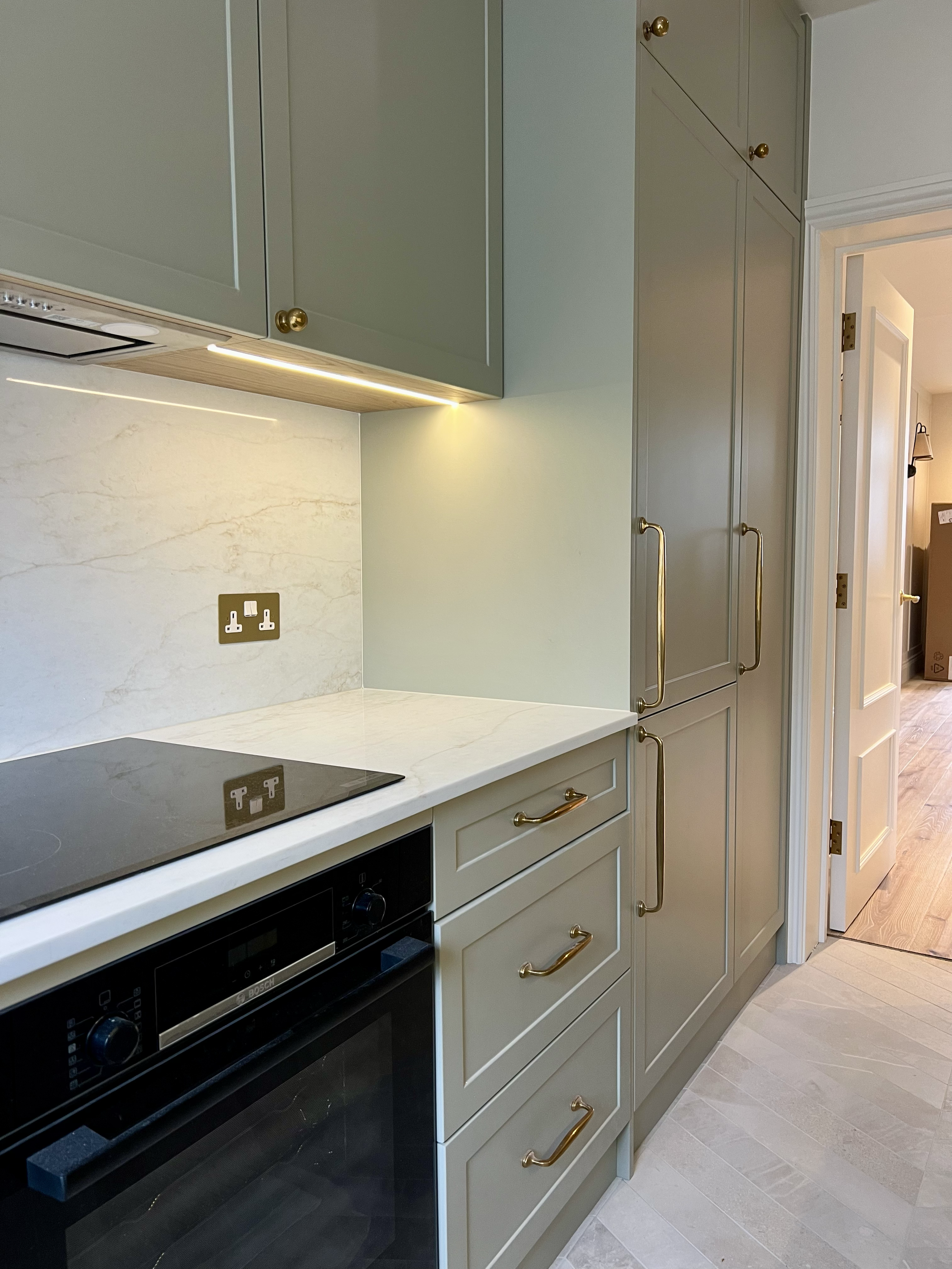 “Bespoke kitchen design with shaker-style cabinets, stone countertops, and integrated appliances.”