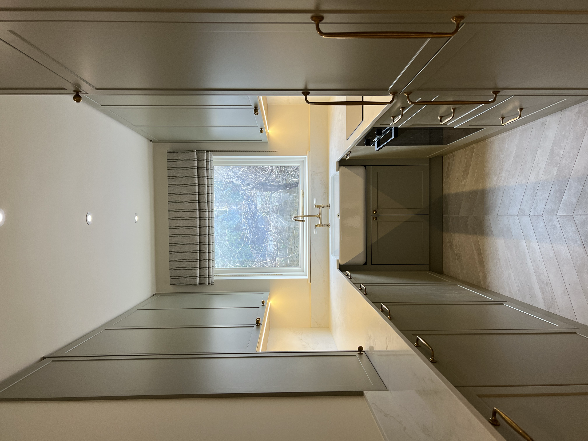 “Bespoke kitchen design with shaker-style cabinets, stone countertops, and integrated appliances.”