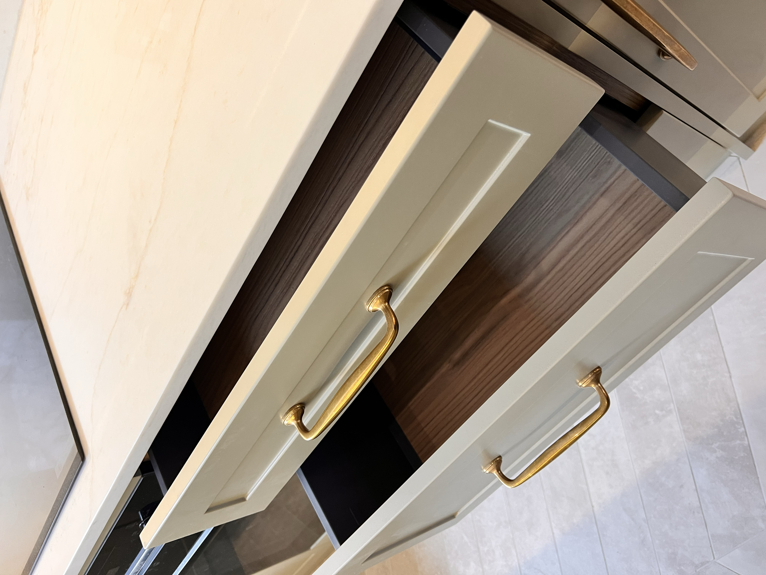 “Bespoke kitchen design with shaker-style cabinets, stone countertops, and integrated appliances.”