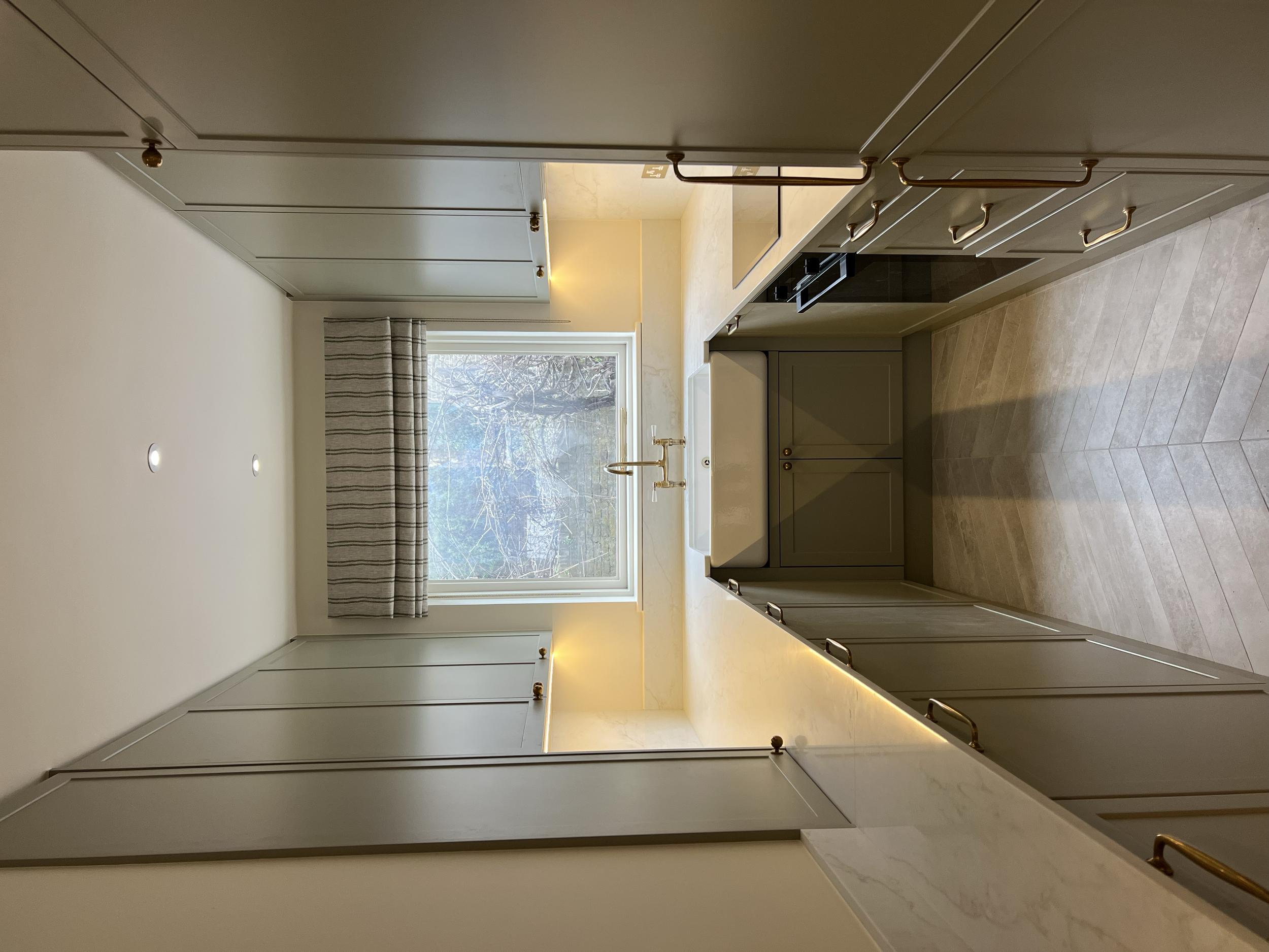 “Bespoke kitchen design with shaker-style cabinets, stone countertops, and integrated appliances.”