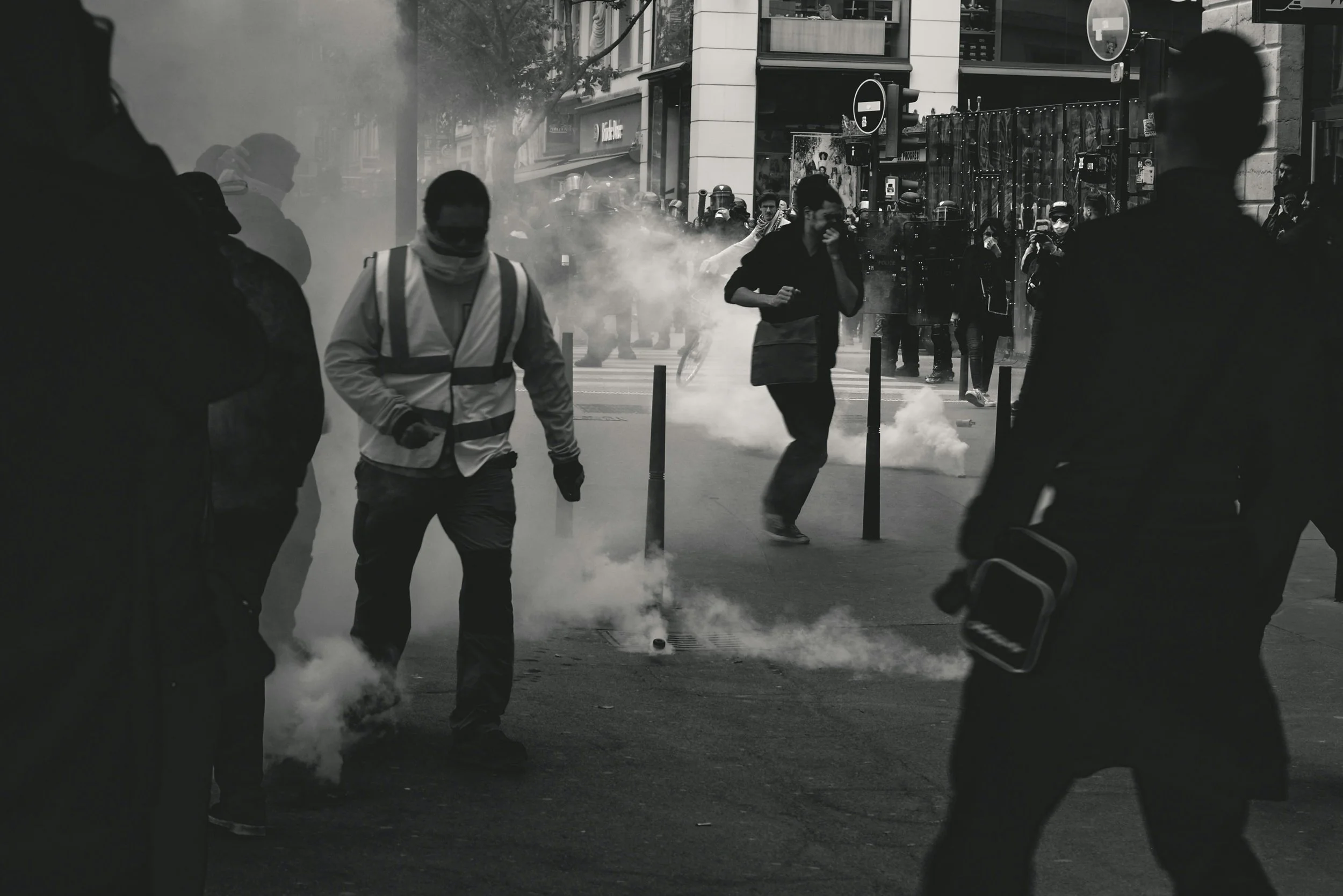 people protesting in the street teargas