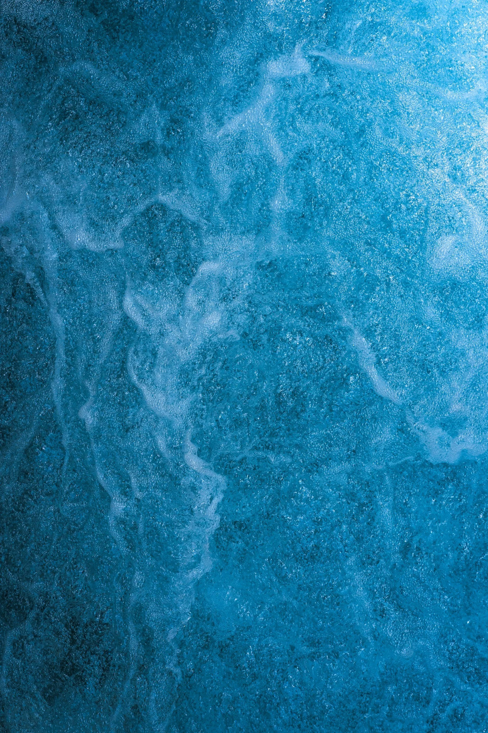 Close-up of ocean water showing waves and foam.