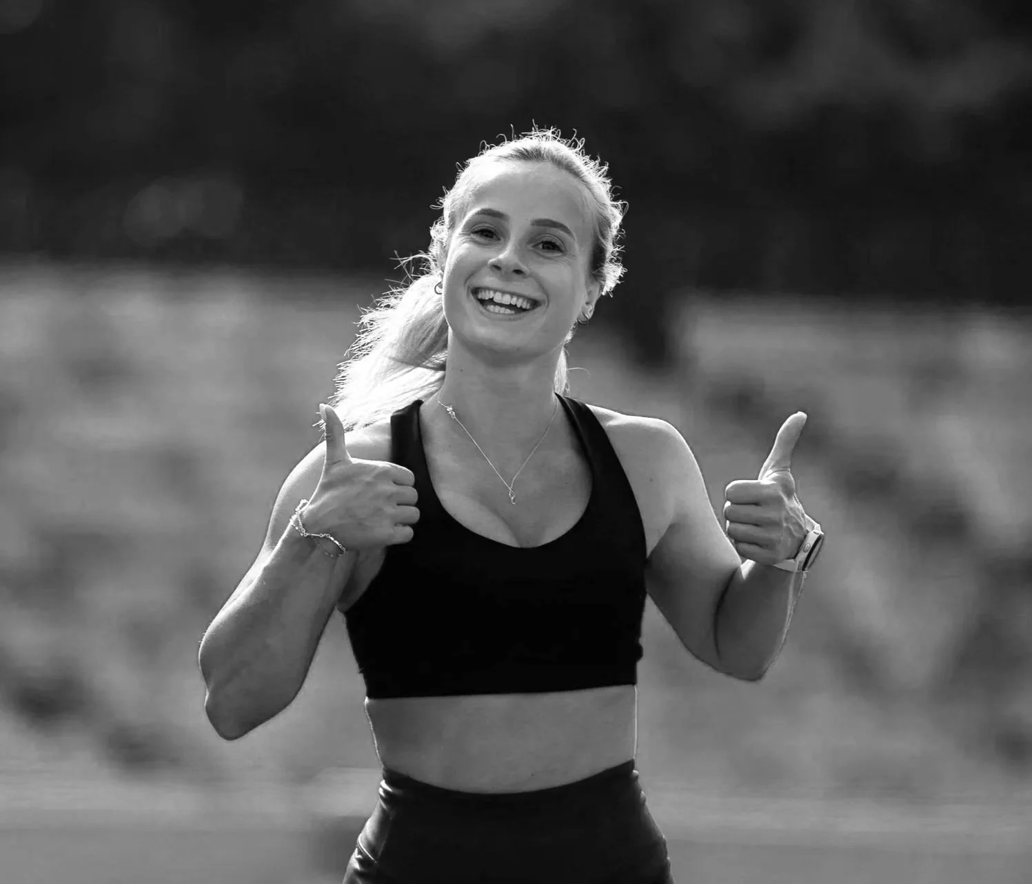 Female deadly dozen athlete thumbs up running towards camera