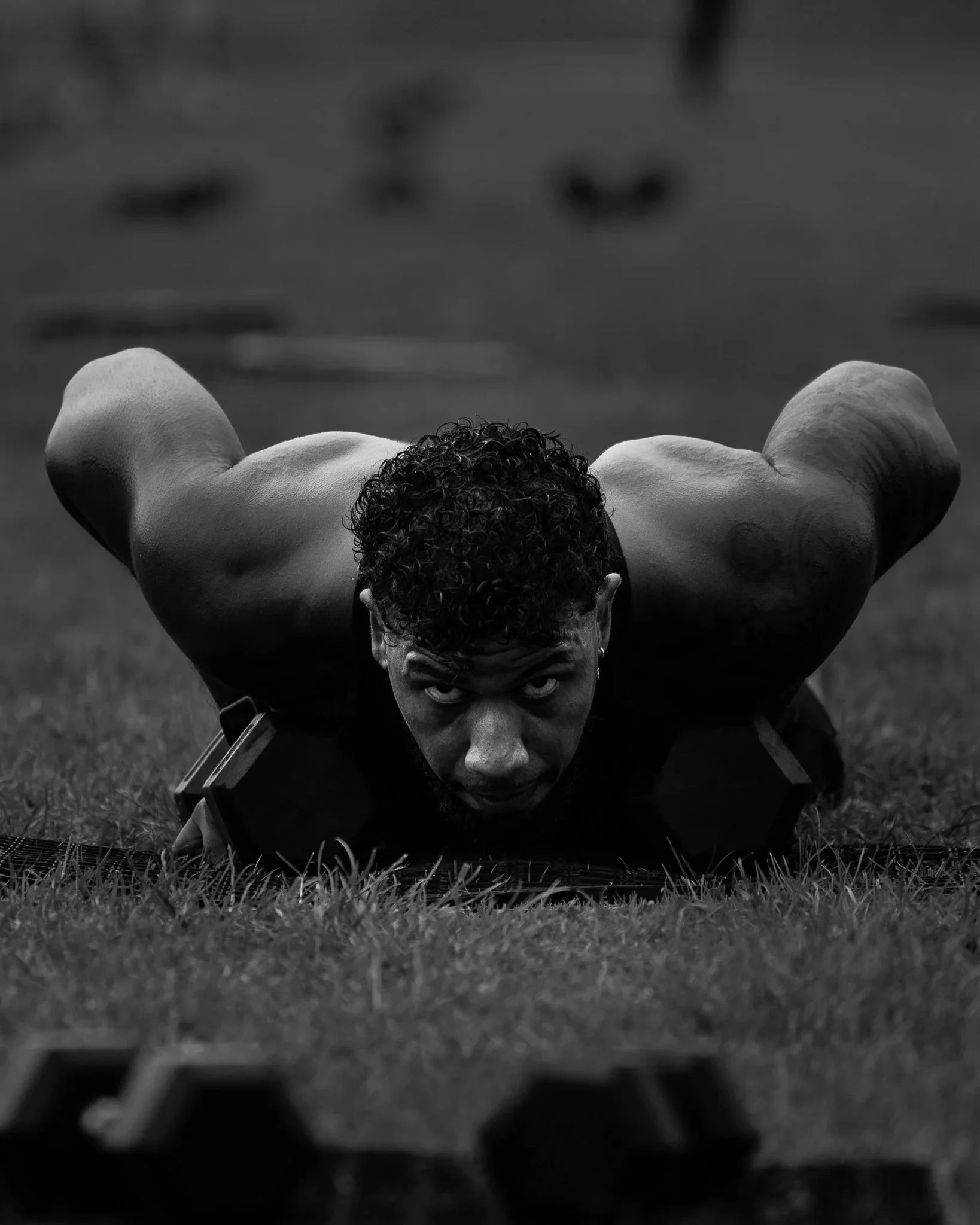 Male athlete on the floor with dumbells during devil press