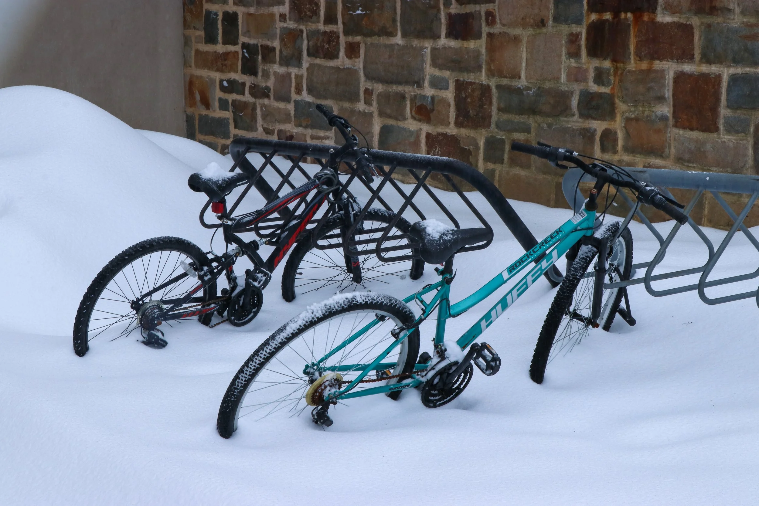 Snow-covered bicycles are pictured locked inside the bike rack outside Fairchild Martindale Library. With snow accumulating from a winter storm, Lehigh moved Monday’s class operations to a remote schedule. (Luke Kaiser/B&W Staff)