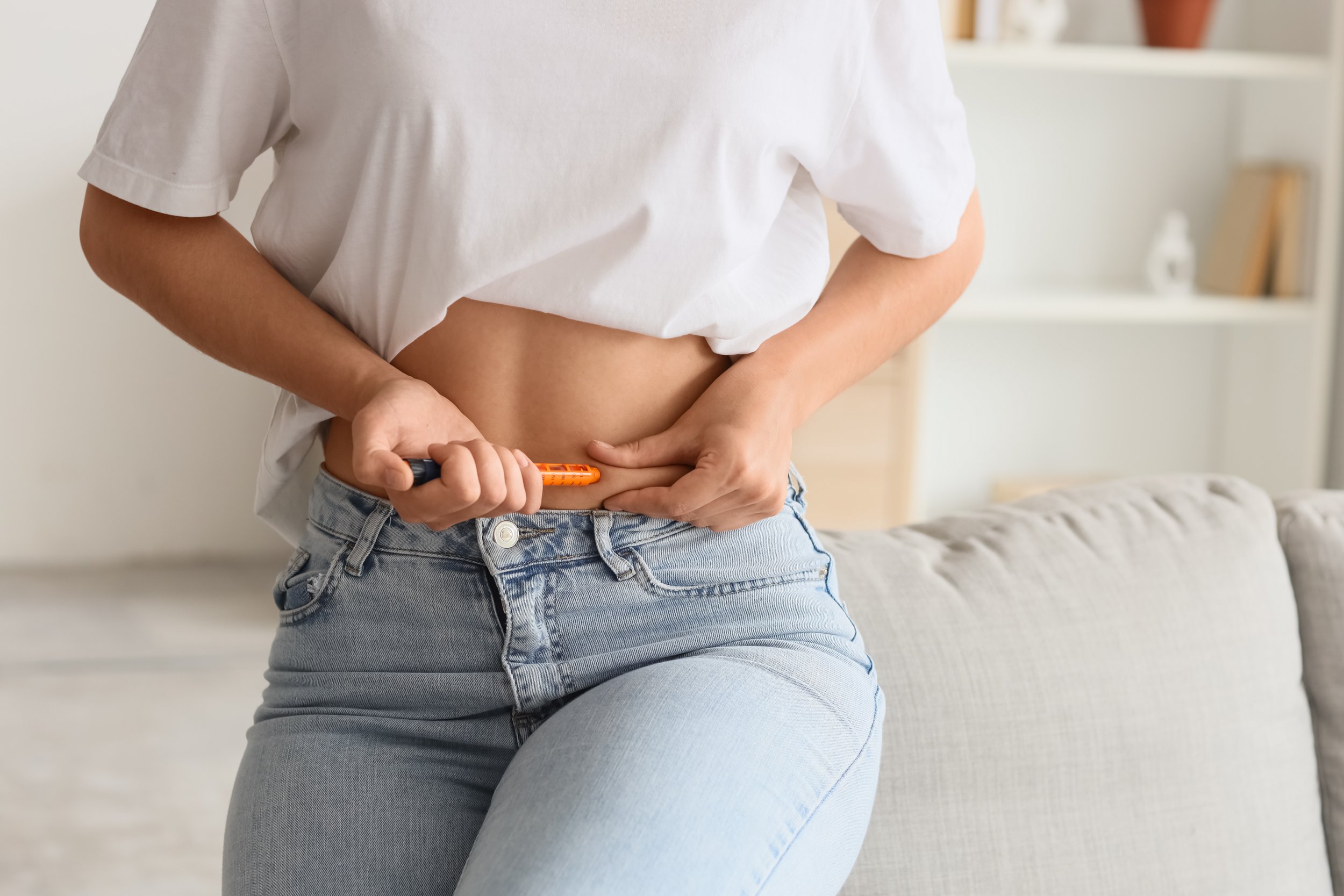 Woman injecting into her stomach