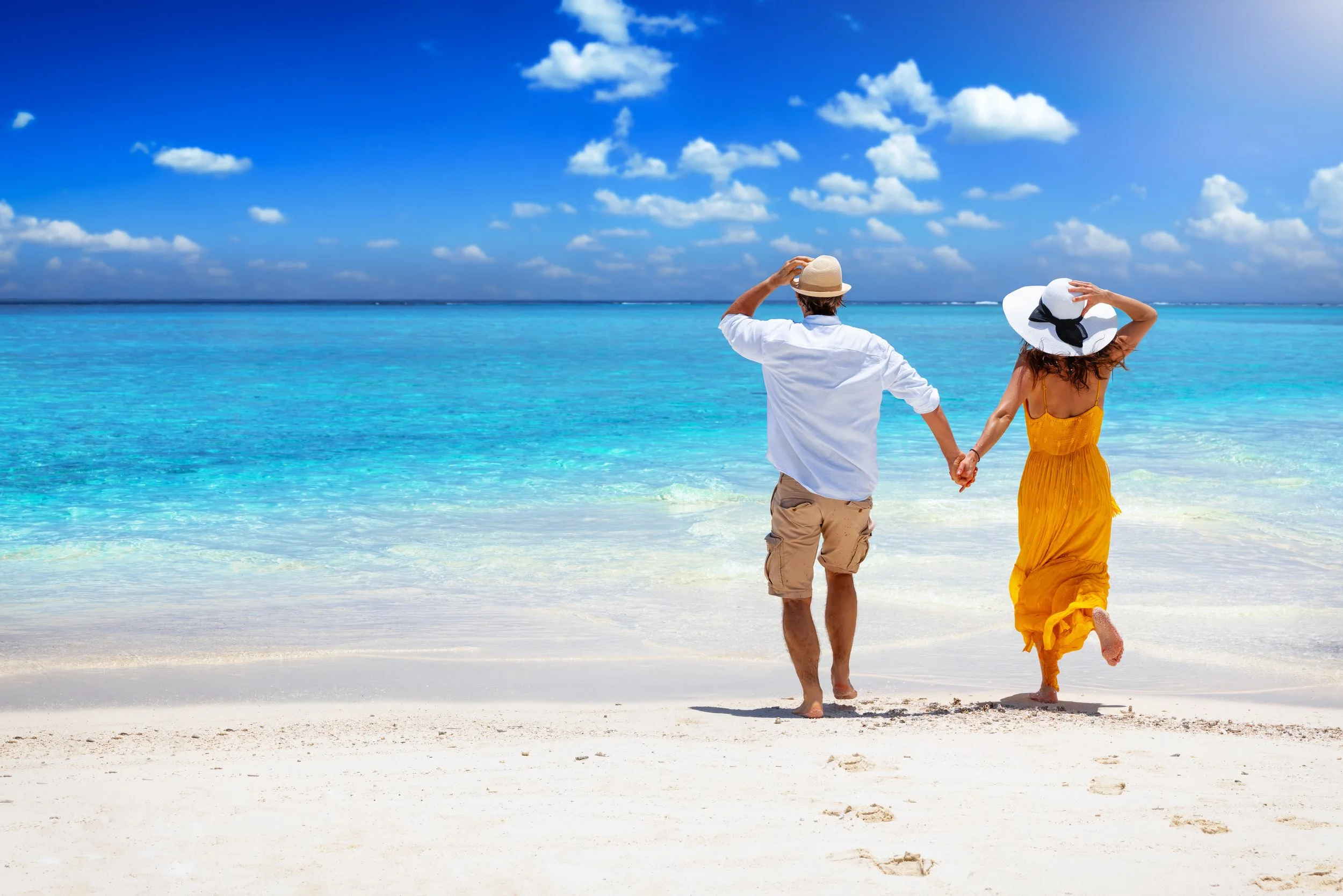 Happy, active couple walking on the beach after getting low-testosterone diagnosed and treated.