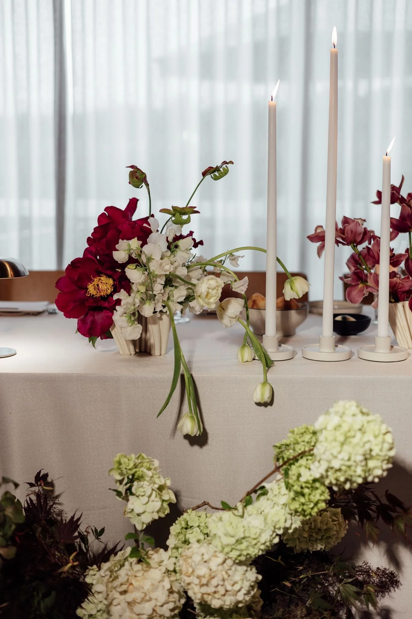 Wedding flowers in ceramic vases for reception tables at Harriet Hubert Estate with dinner candles