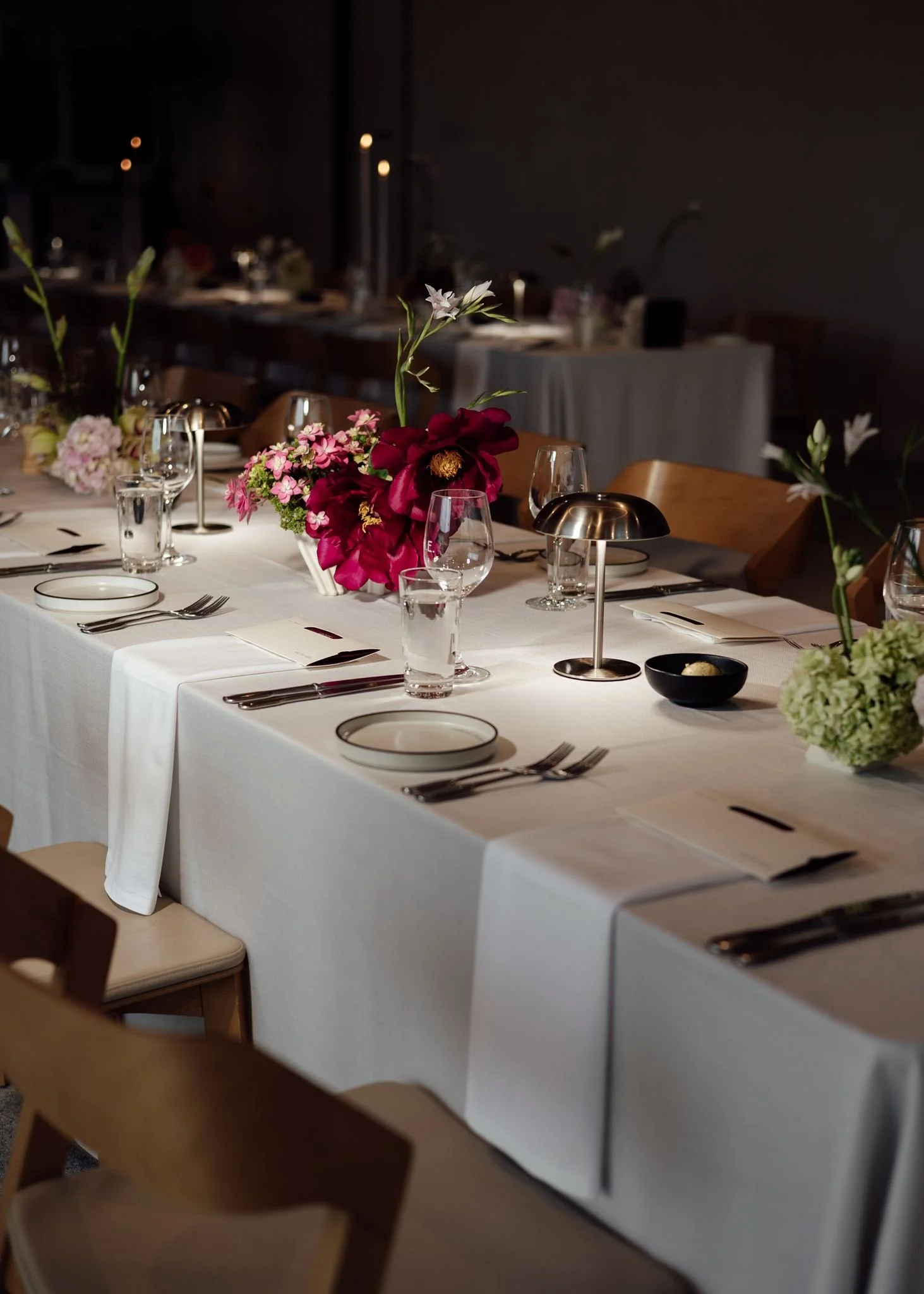 Wedding flowers in ceramic vases for reception tables at Harriet Hubert Estate with chrome lamp 