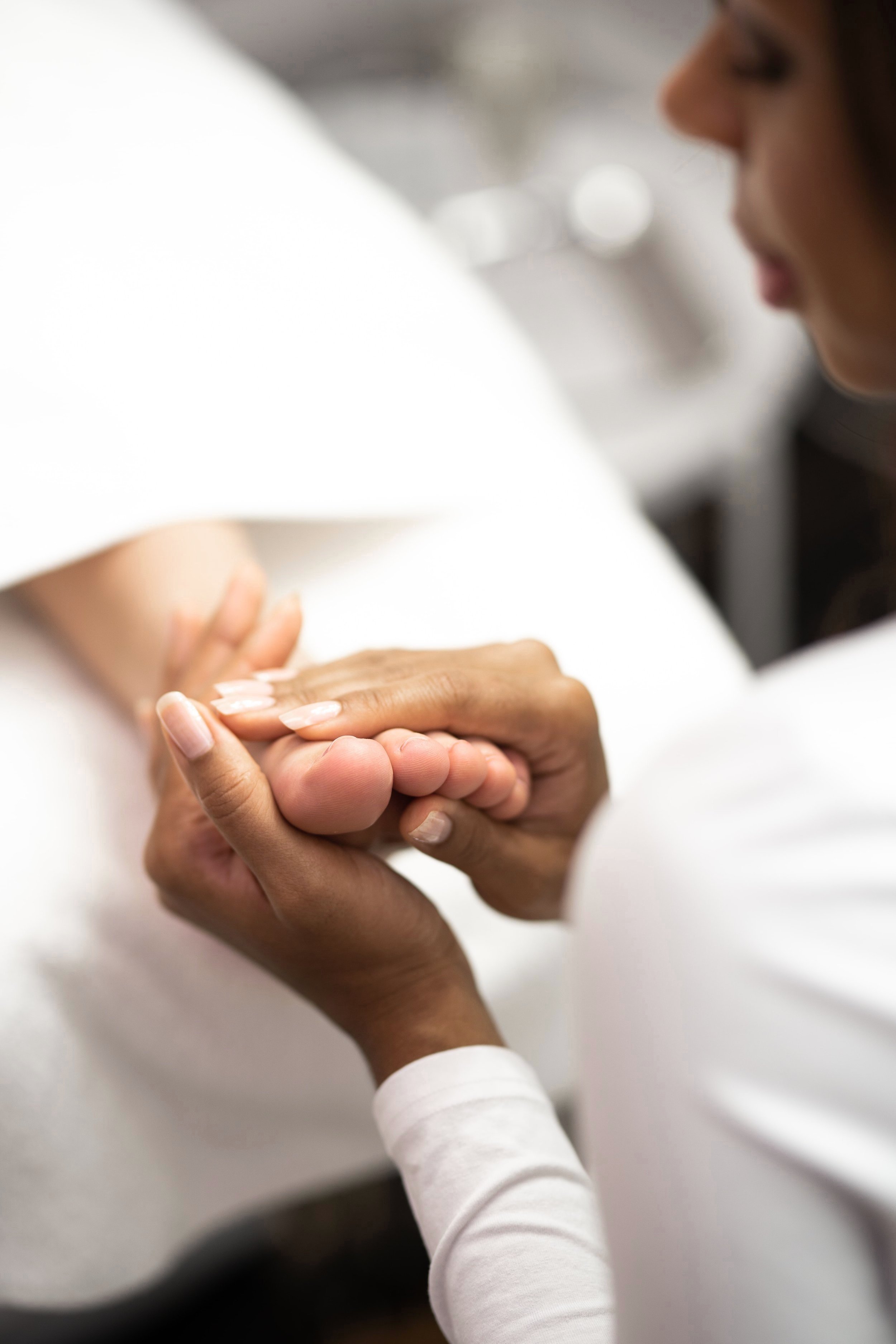 Hände massieren behutsam einen Fuß in Nahaufnahme