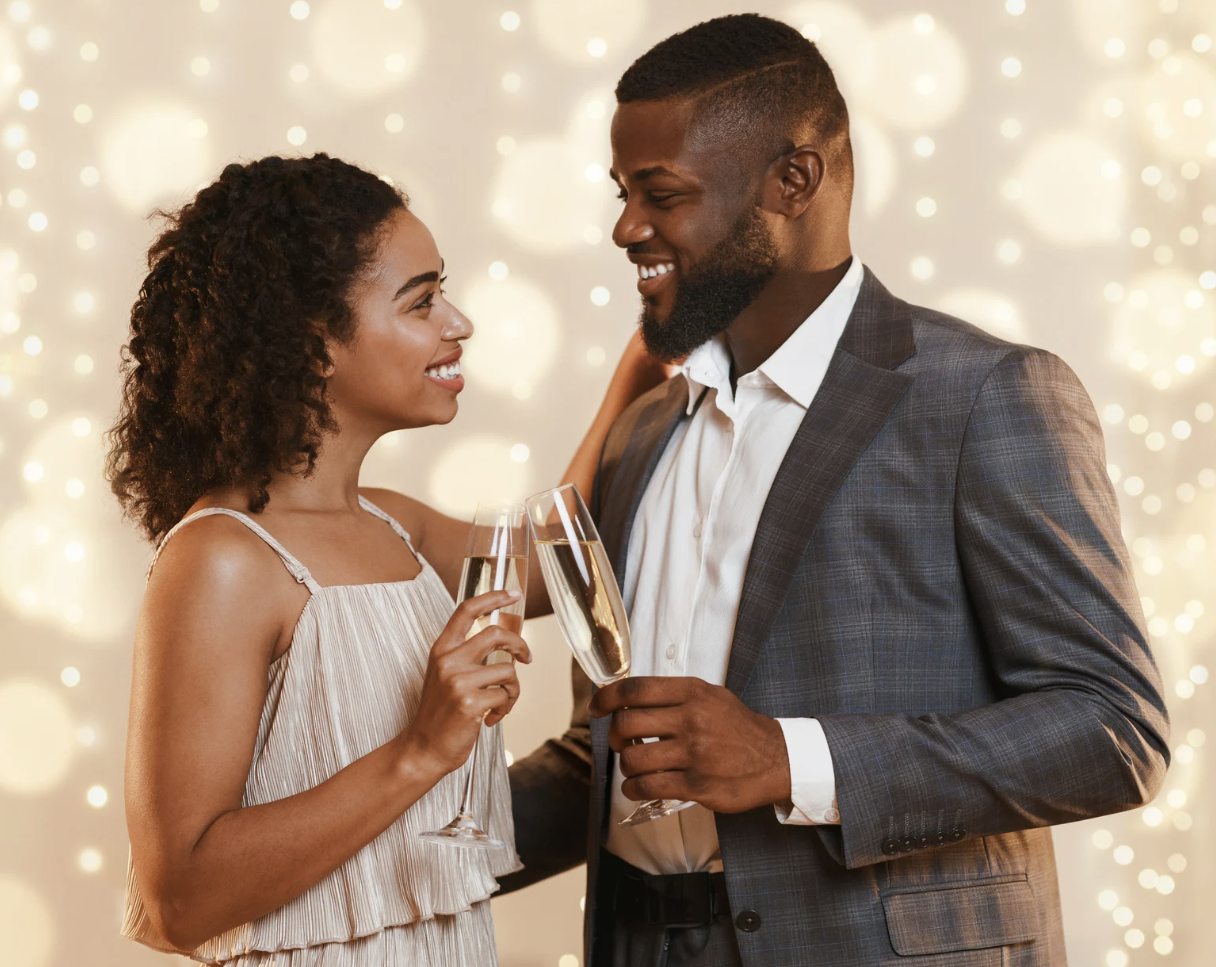 A couple in formal attire sharing a toast with champagne at a celebration or party.