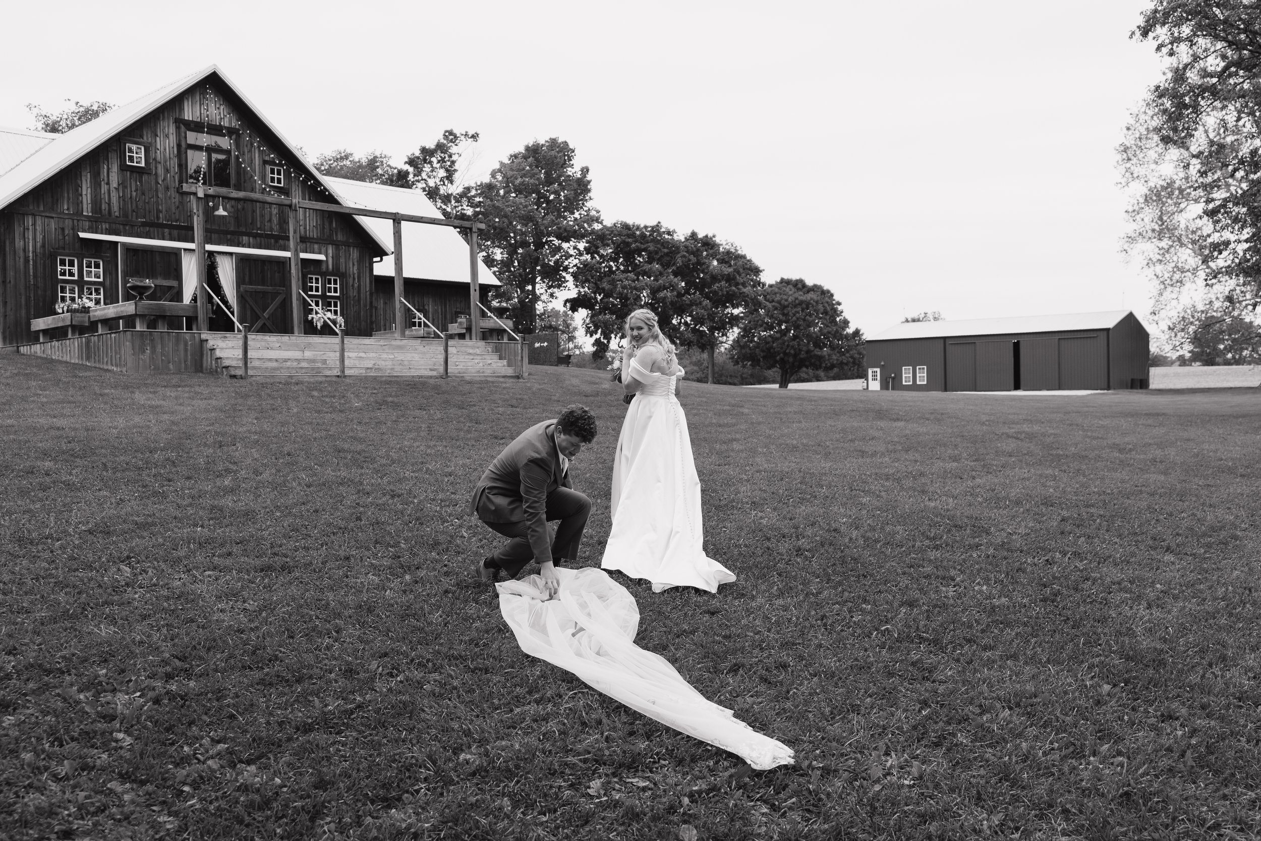 groom helping bride with veil