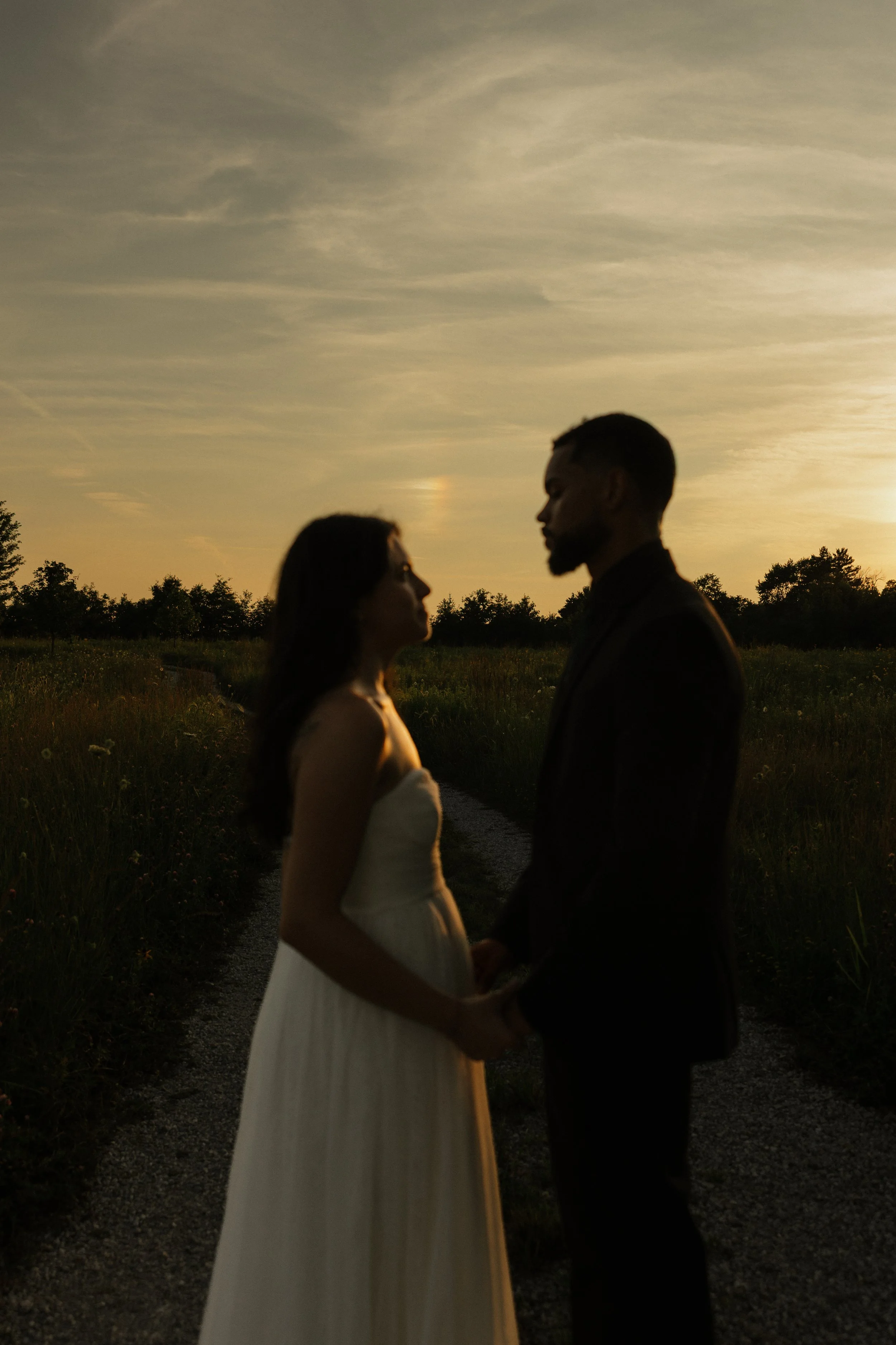sky at sunset with bride and groom 