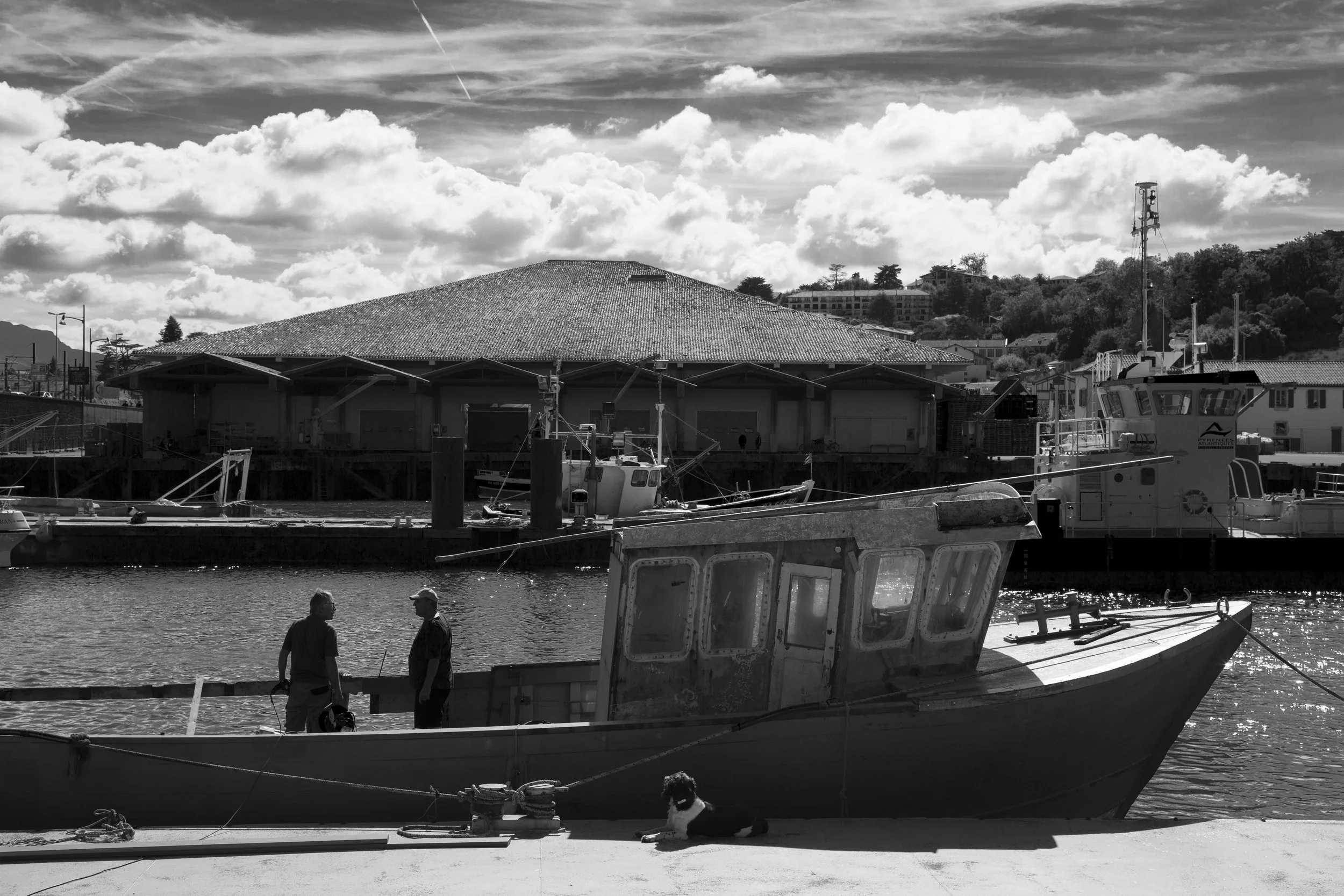 Fishermen in silhouette on a boat on a beautiful sunny day in St-Jean de Luz, France