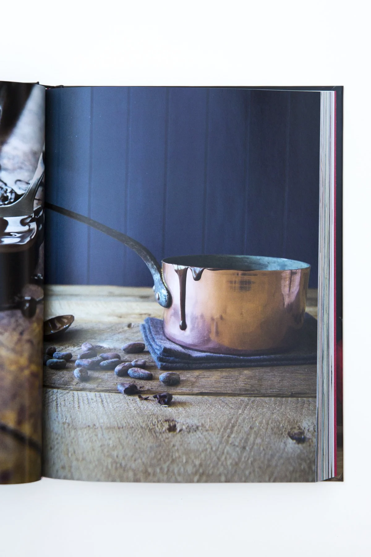 Open cookbook showing a copper pan with melted chocolate running down the side