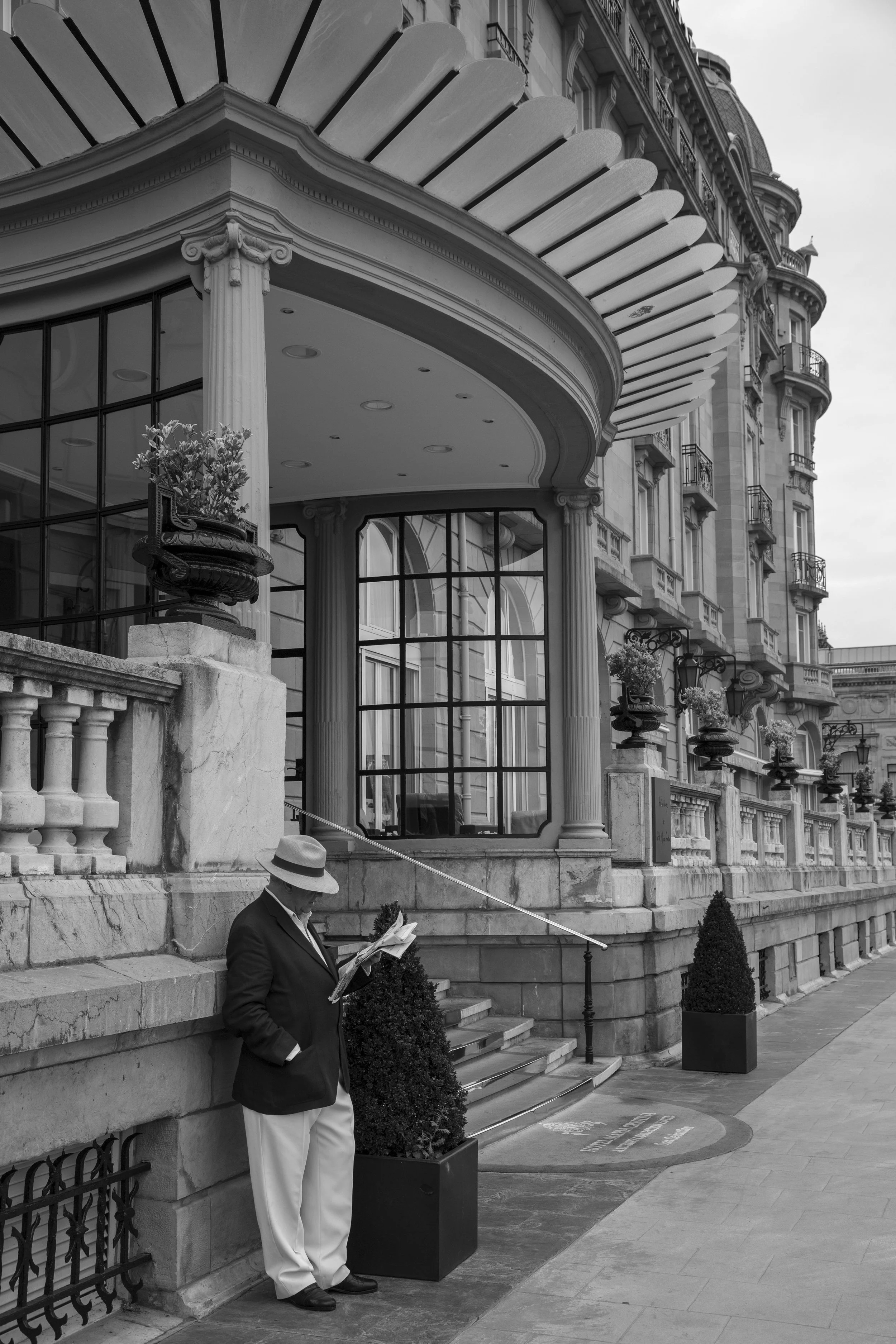 Distinguished man reading the morning paper in front of the Grand Hotel in San Sebstian, Spain