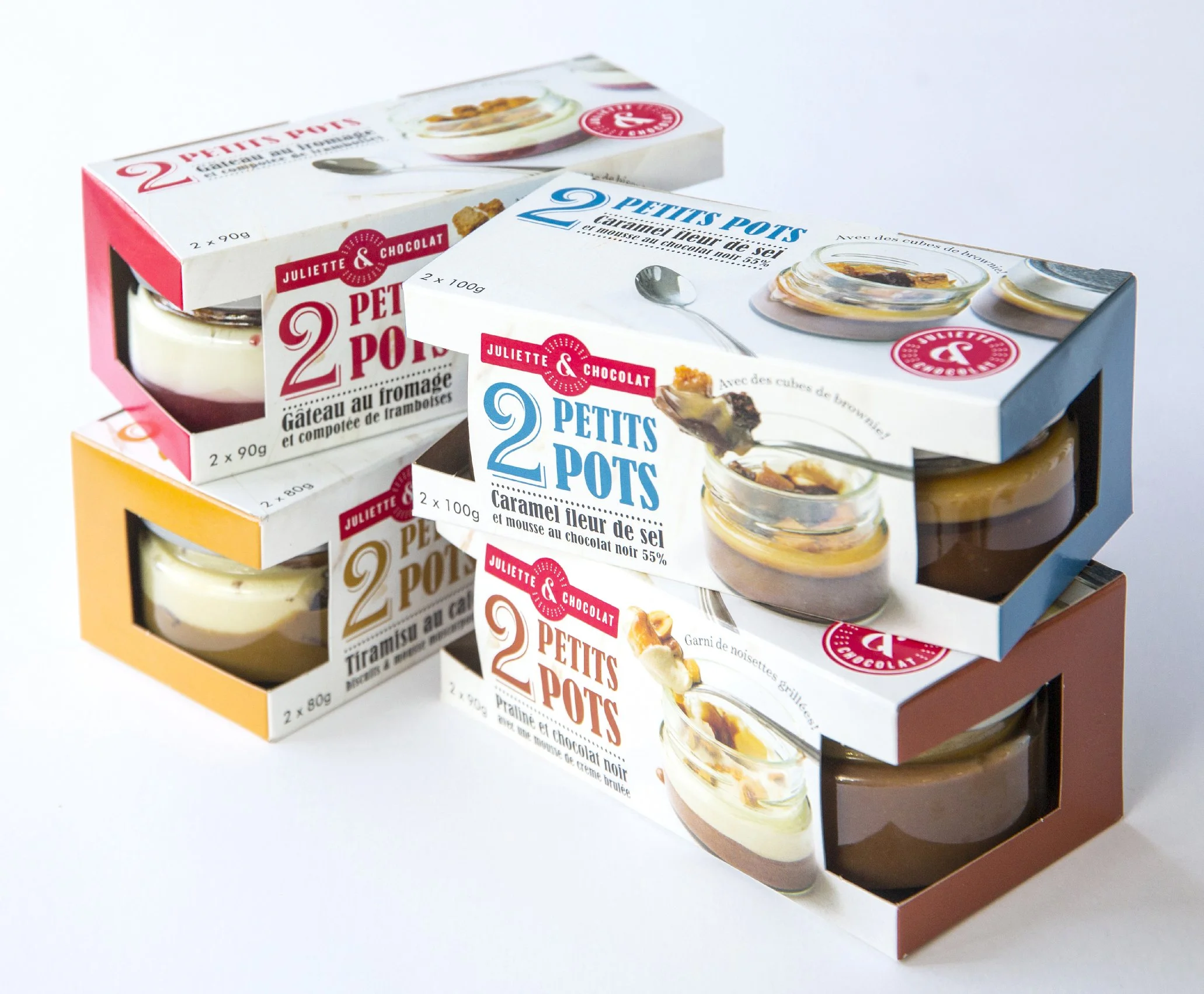 Line of pastries in their retail packaging: cheescake, chocolate mousse and hazelnut mousse