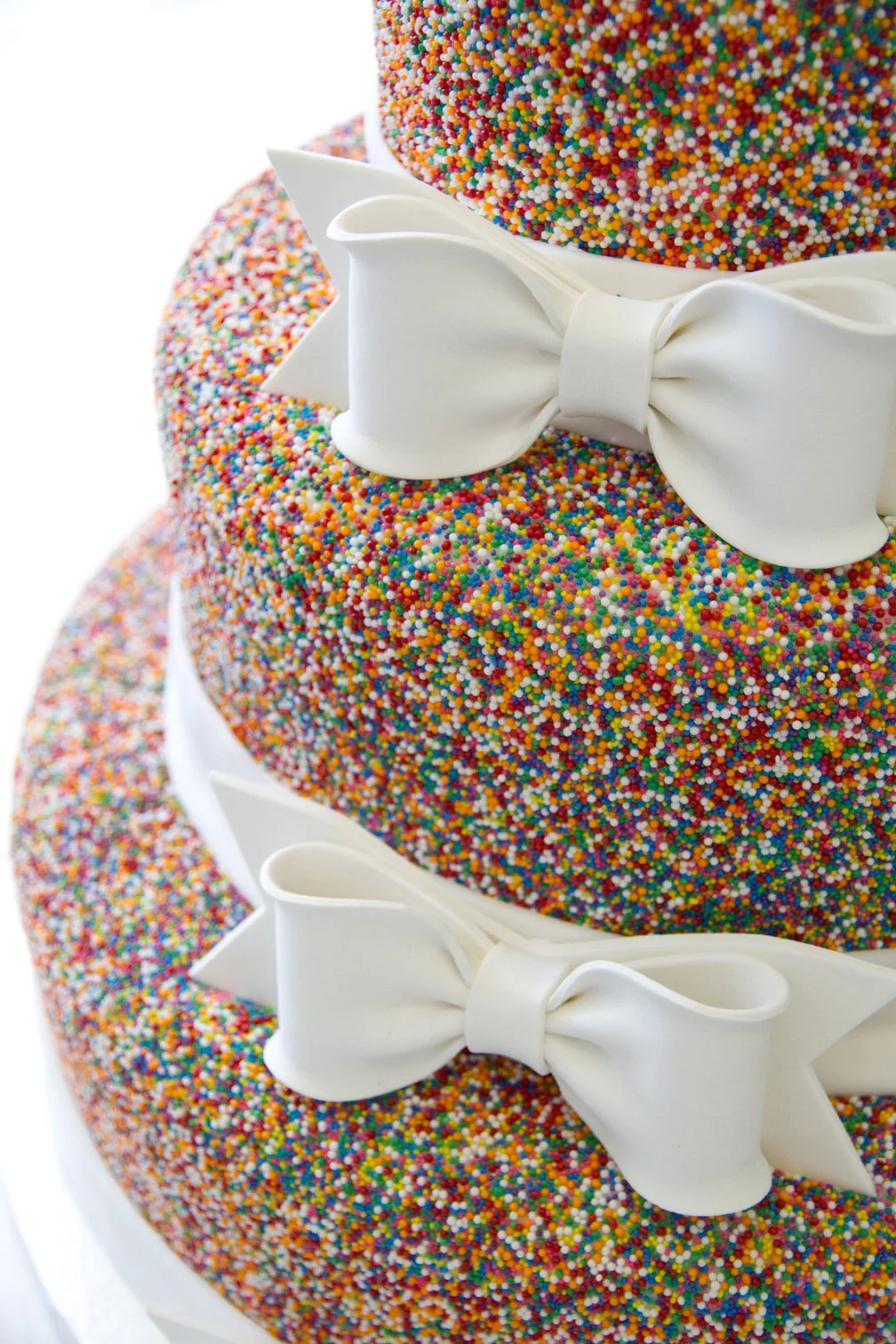 Elegant wedding cake covered in colorful sprinkles and decorated with colorful spinkles