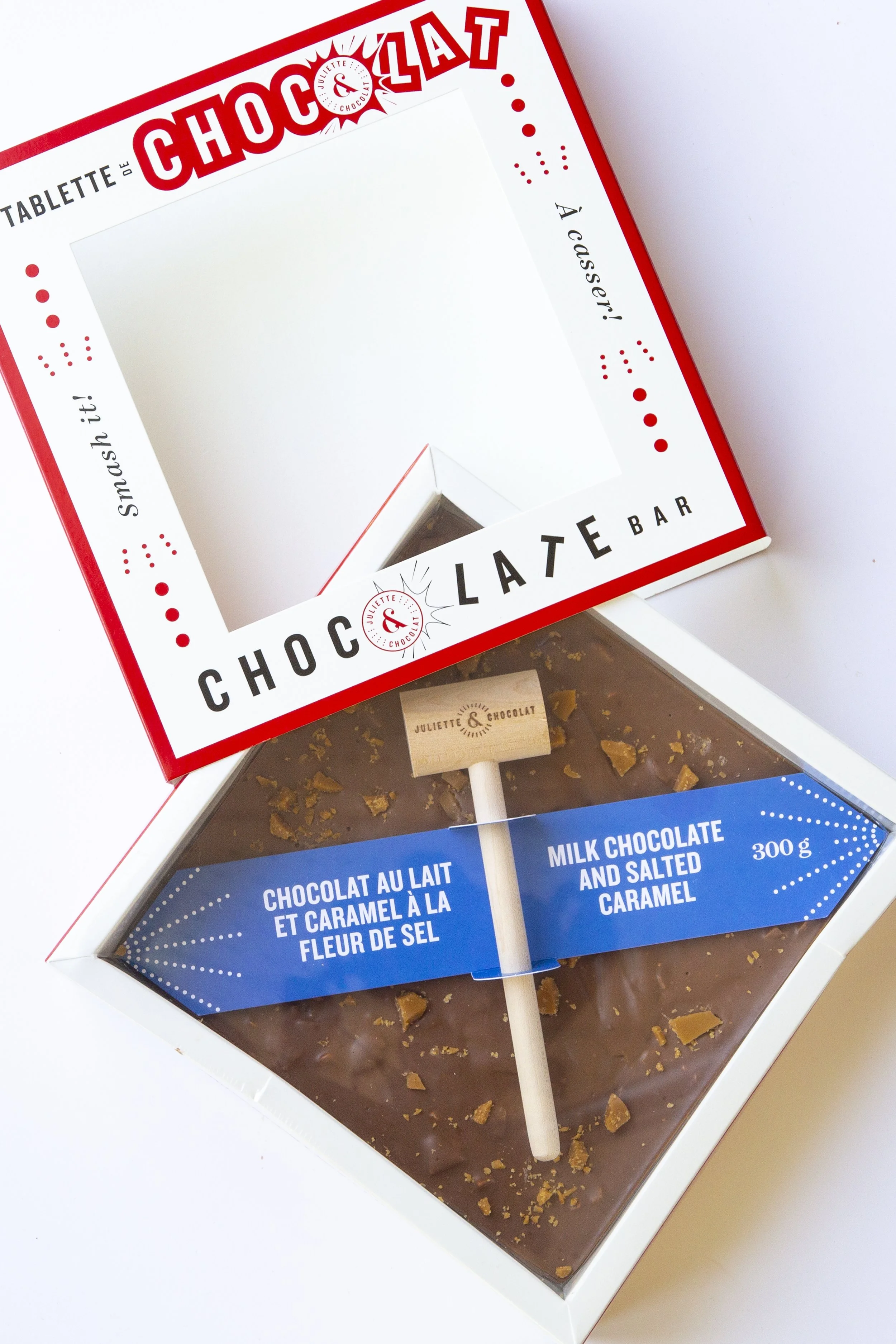 Open chocolate box, with large square chocolate bar and crunchy caramel bits in the chocolate. 