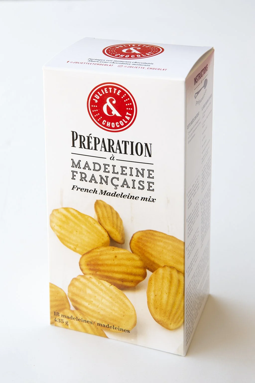 French madeleine cooking mix in a white box with photo of fluffy madeleines. 