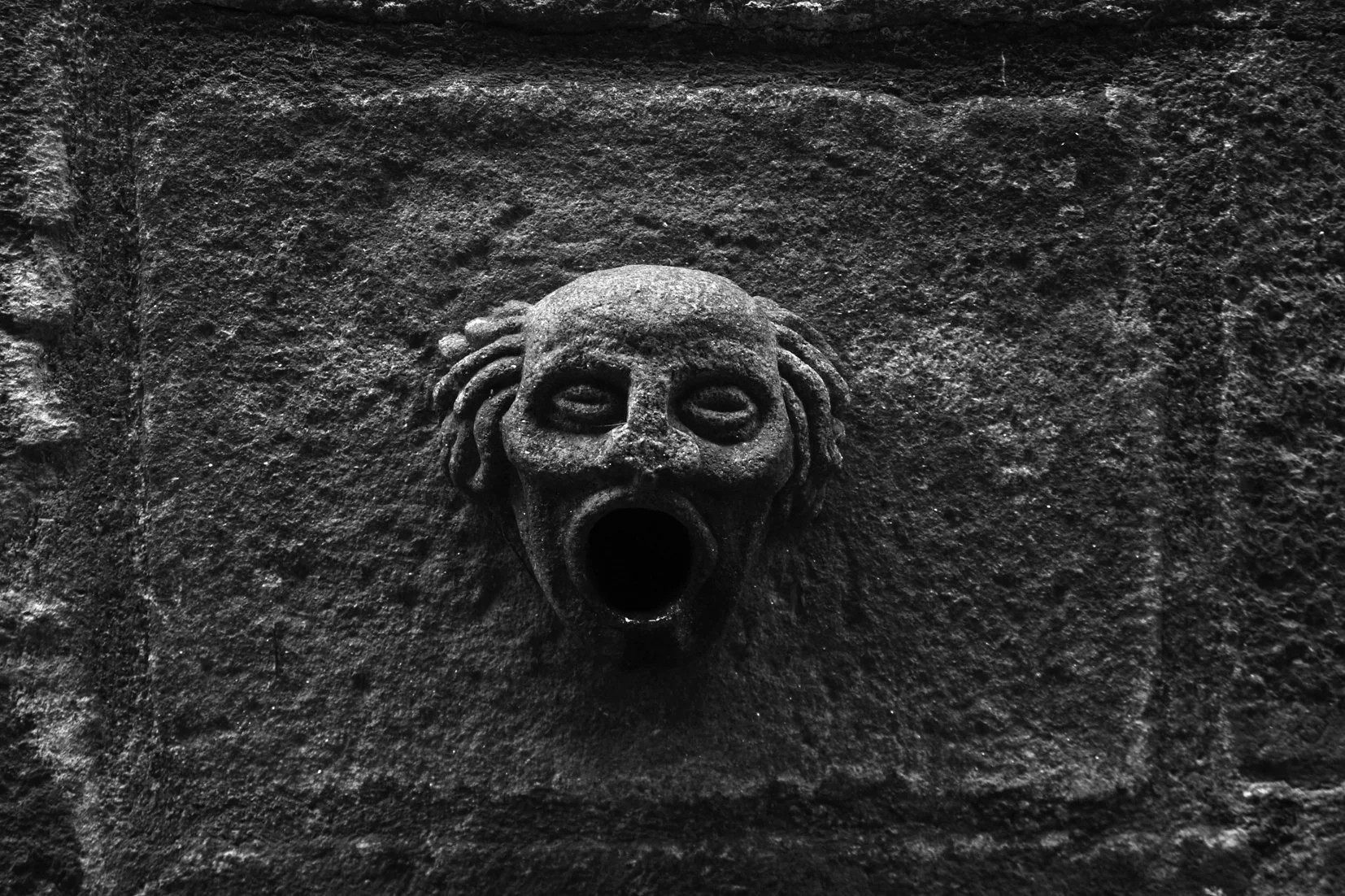 A small stone fountain photographed in Greece, old sculpture