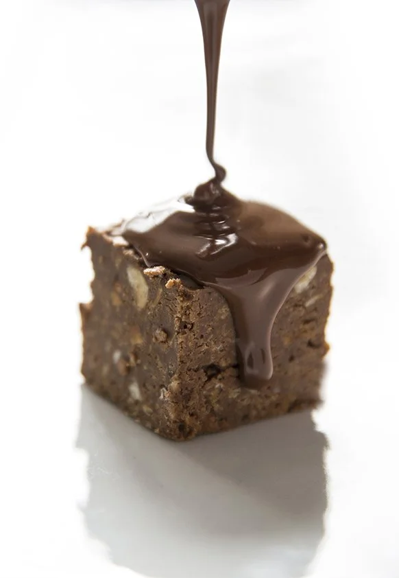 Crunchy milk chocolate and hazelnut cube with warm liquid milk chocolate being poured over