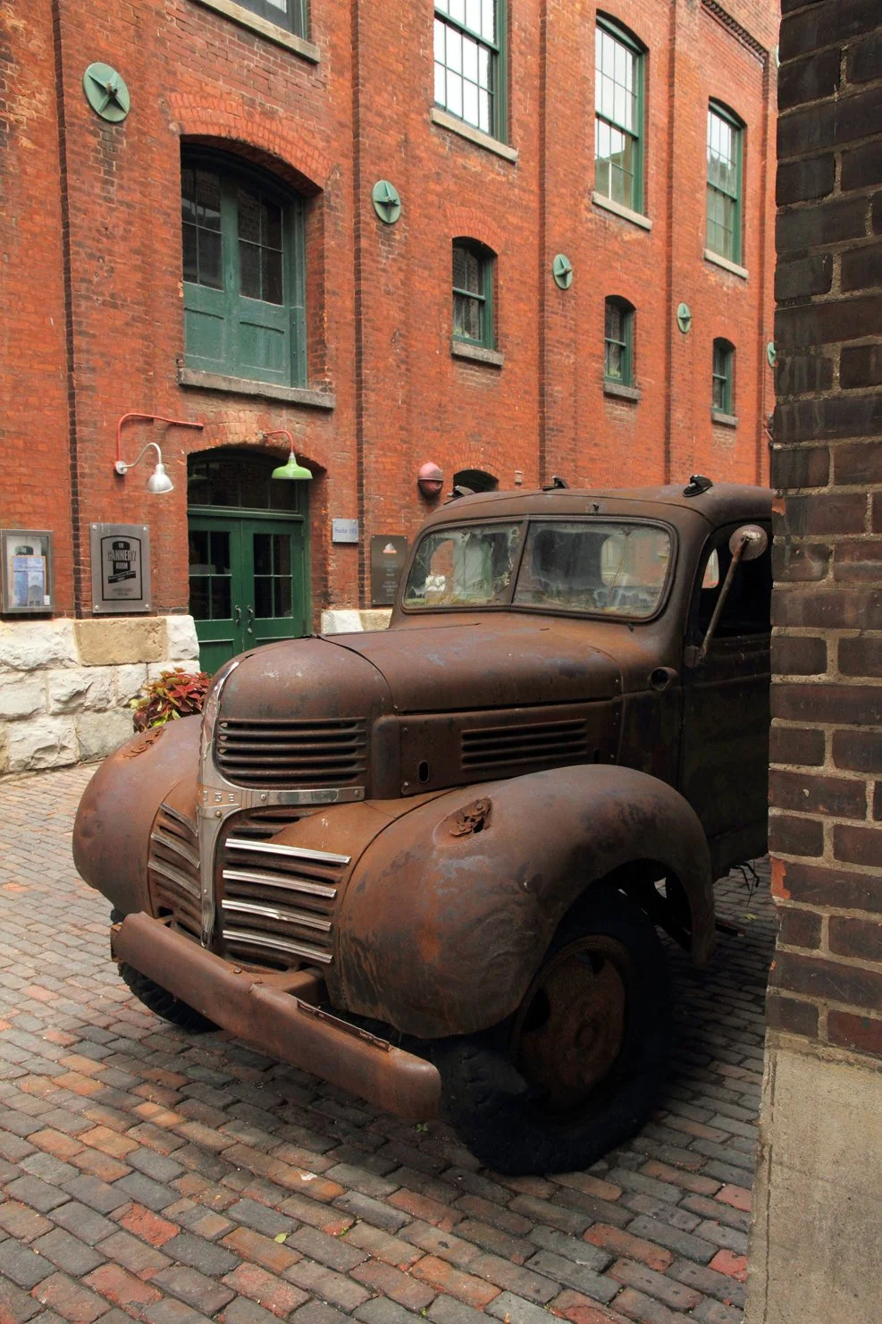 Old rusted abandoned truck in Toronto, Canada, beautiful old brick buildings, old cobblestone streets