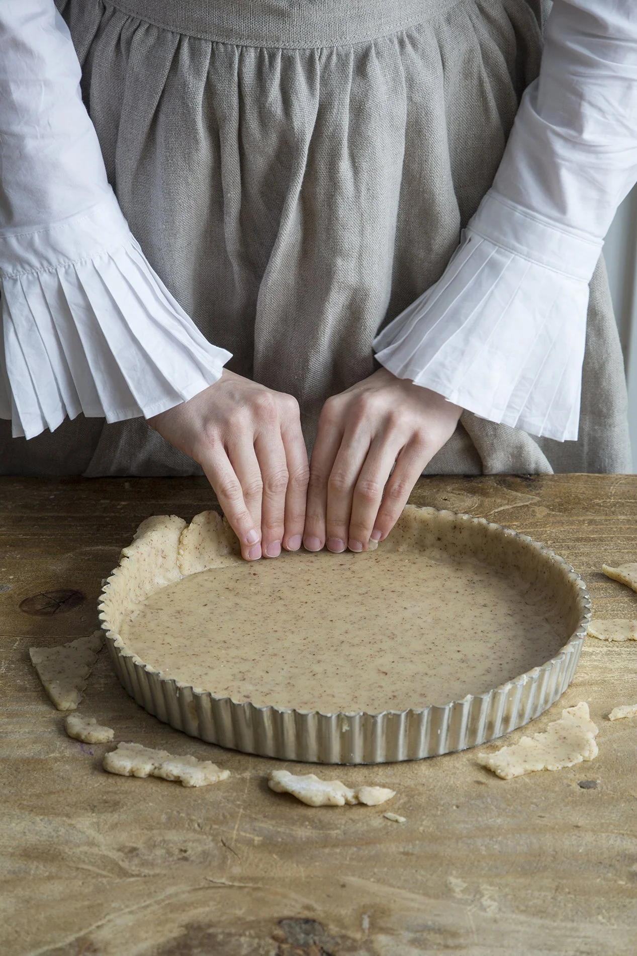 Hands forming a pie crust in a beautiful kitchen on a wood table 
